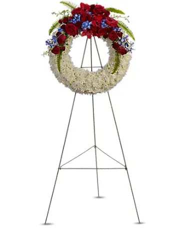 Standing funeral wreath with red and white flowers on a metal easel