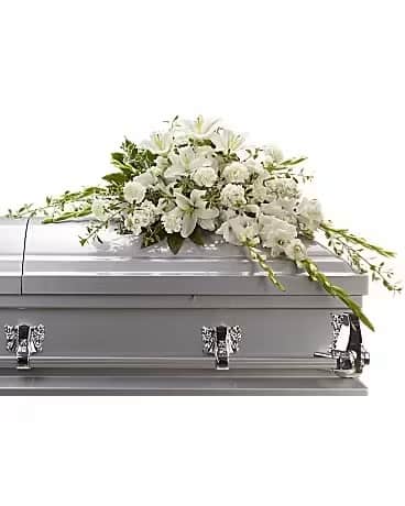 White floral casket spray on a silver casket