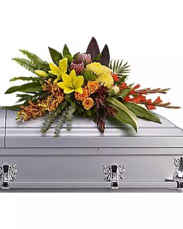 Colorful floral spray arranged on a silver casket