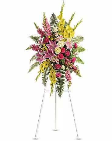Tall standing floral spray with pink, yellow, and white flowers on a metal easel