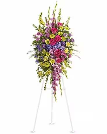 Tall standing spray of pink, purple, and yellow flowers on an easel