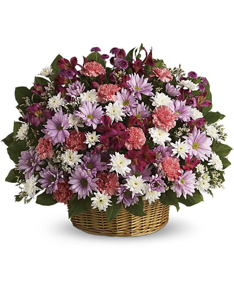 Mixed pink, purple, and white flowers in a wicker basket