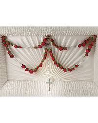 White casket spray with red rose garlands and a cross