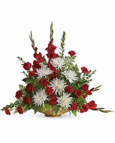 Red and white floral arrangement in a wicker basket