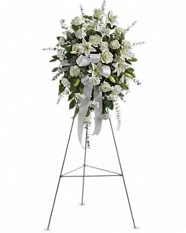 White floral standing spray on an easel with ribbon
