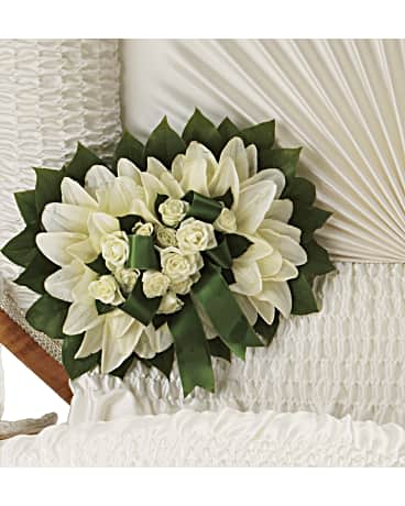 White floral bouquet with green ribbon accents on a white chair