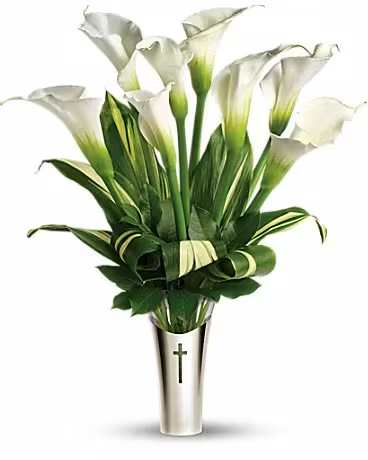 White calla lilies in a silver vase with a cross