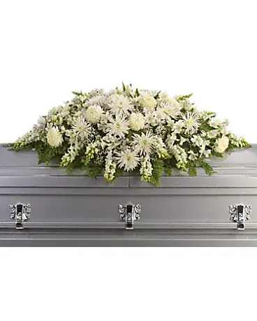 White floral casket spray with a silver casket