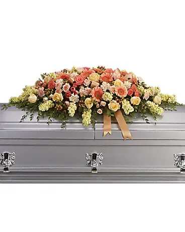 Pastel floral casket spray on a silver casket