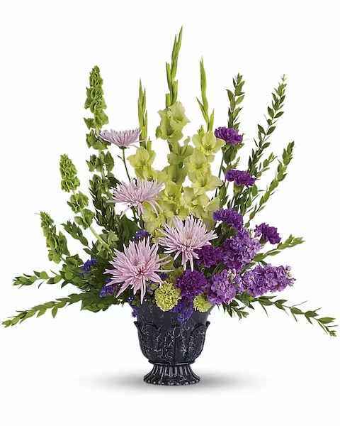 Purple and green floral arrangement in a black urn vase