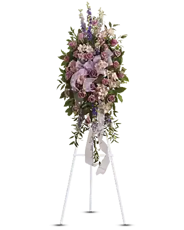 Tall floral standing spray with pink and lavender flowers on a white easel