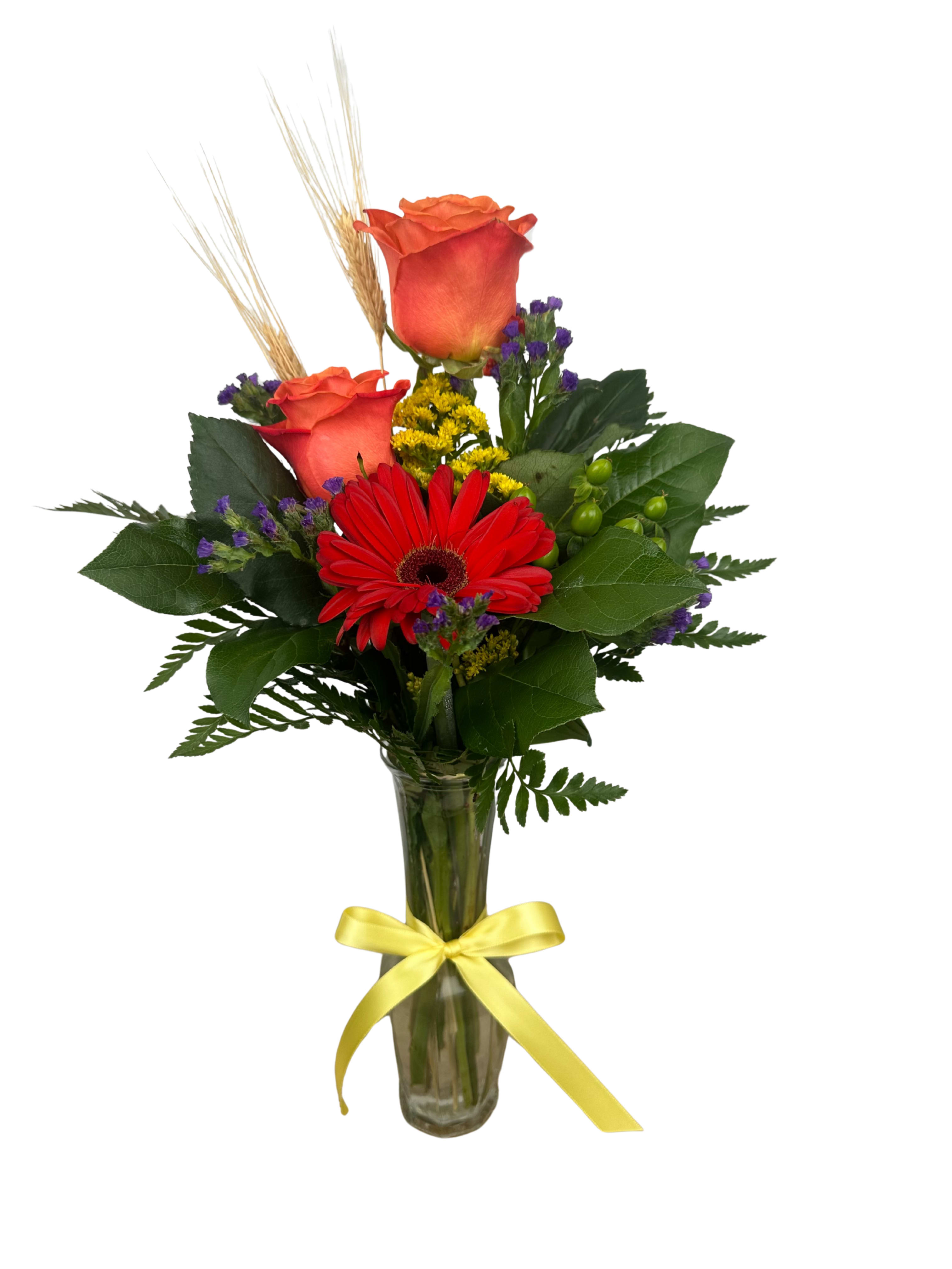 Bouquet of red roses and a red gerbera daisy in a glass vase