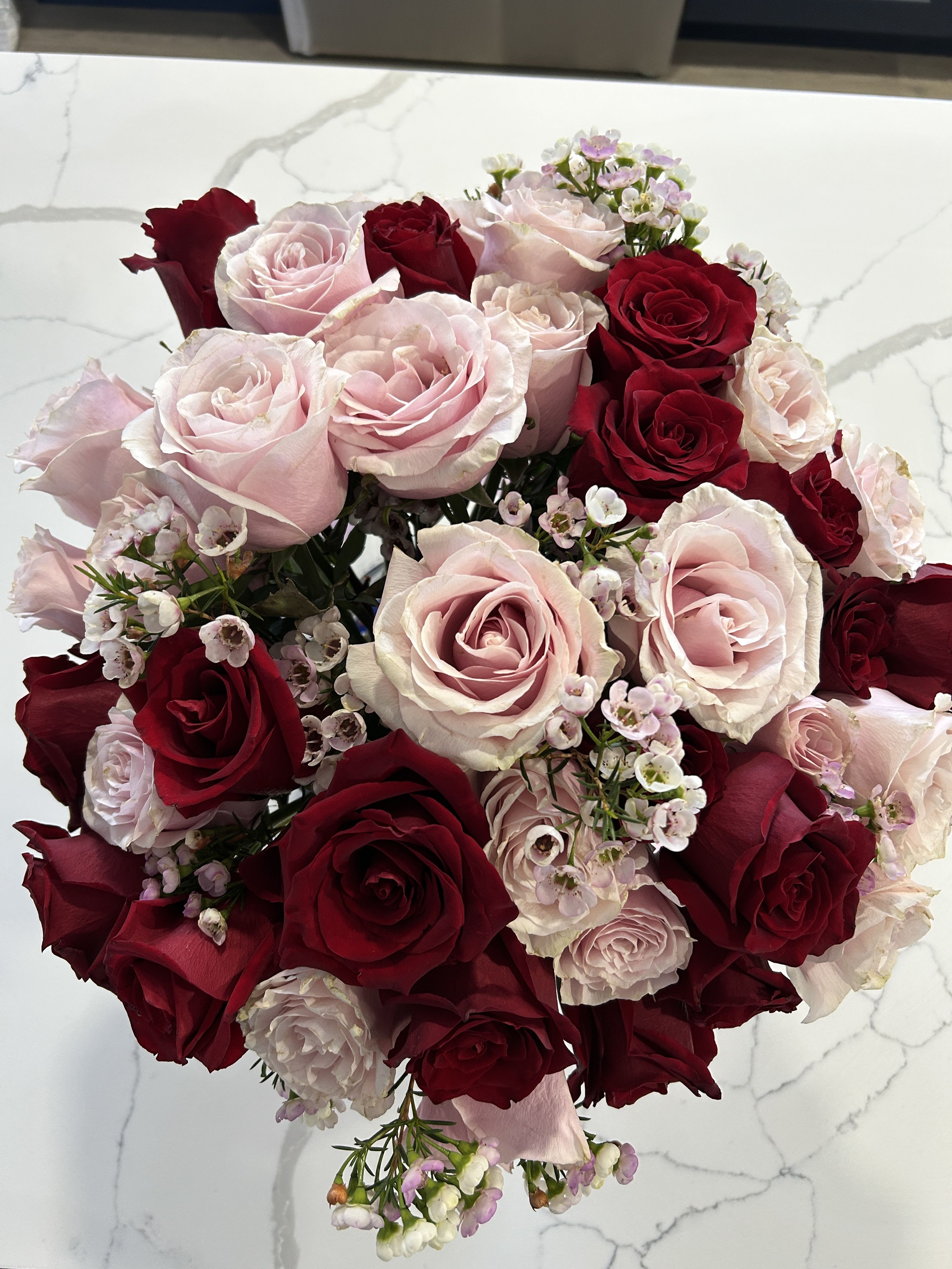 Bouquet of red and pale pink roses with small white filler flowers
