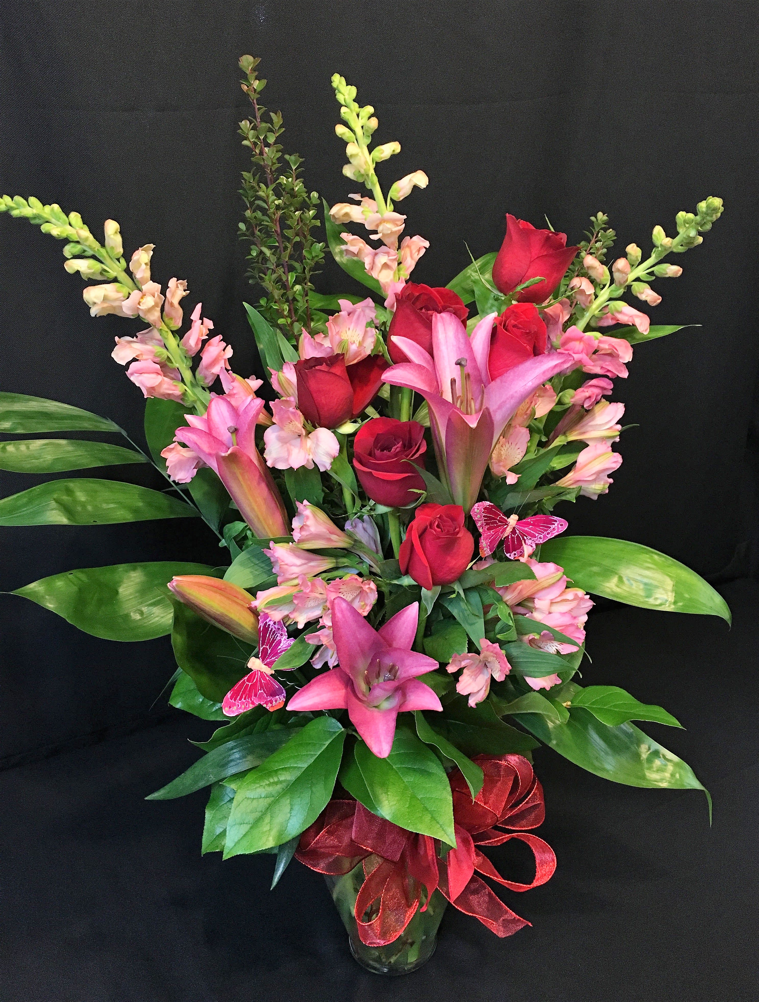 Oriental Lilies with Red Roses and Butterflies - Pungent sweet smelling lilies, our premium Long stem red roses, and a pair of decorative butterflies flying through them.  What more could she ask for this Valentine's day?  This is a tall stylish arrangement you can be proud to give.