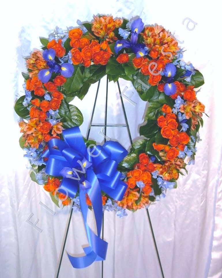 Heart-shaped floral wreath with orange and blue flowers on an easel