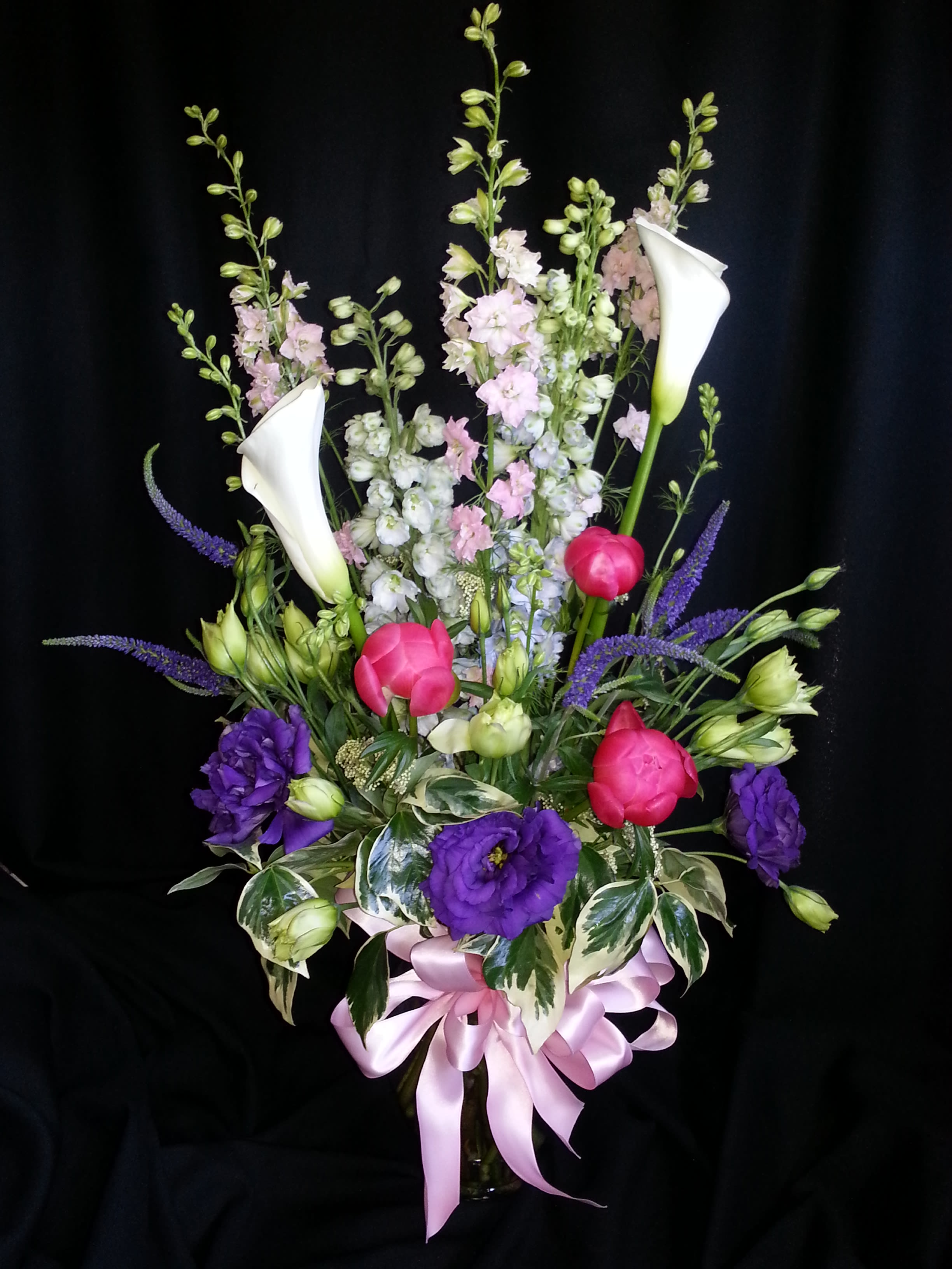 English Garden Spring Flowers, with Callas and Peonies - An amazing full flower arrangement with a gorgeous bow and quality vase for Mother's day; Premium spring assortment of English cottage flowers; We will use pastel colors and only the freshest flowers. Shown here: larkspur, peonies, calla lilies, veronica and lisianthes. Assortment May Vary.  If you want the best for your bouquet order ahead for the widest selection.  Order by 5/5 and receive 3 Free roses in this arrangement!