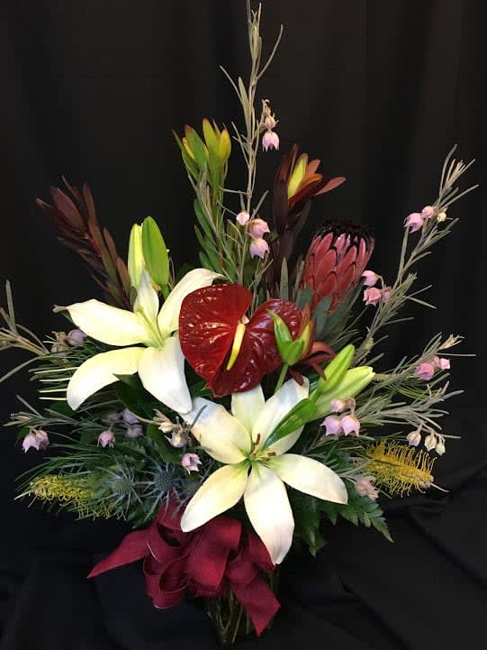 Lilies and Aussie Bells - A festive mix of Australian and California flowers, even a tropical anthurium when seasonally available. Australian flowers used are Aussie bells, grevillea, queen protea and leucadendron.* Order in advance for best selection.