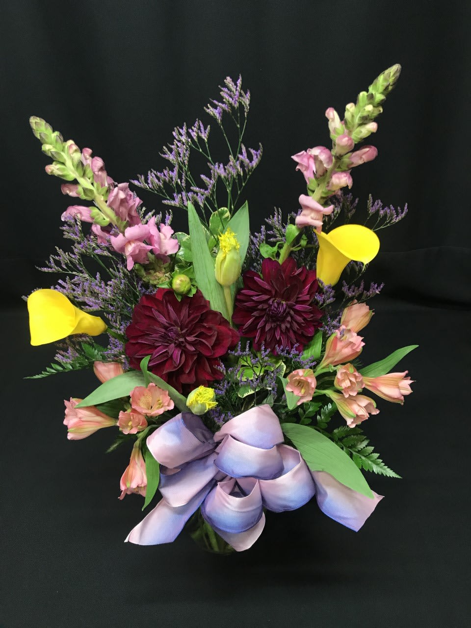 Dahlia spring mix - Smaller size spring mixed bouquet full of premium flowers. A very romantic choice for:  ANNIVERSARY flowers a week before The Big Day ~ these lovely spring flowers will surely stir up wedding day memories!  Shown here are premium wine colored dahlia with calla lilies and fringe tuliips* - available at various times of year but colors or variety of flowers may need to be substituted