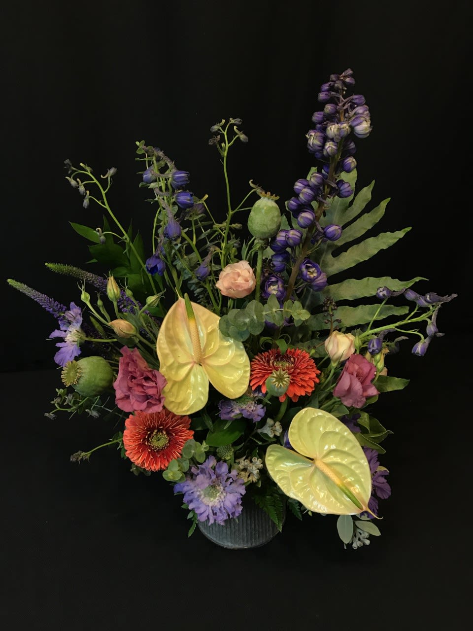 Mixed bouquet with purple, pink, and yellow flowers in a vase