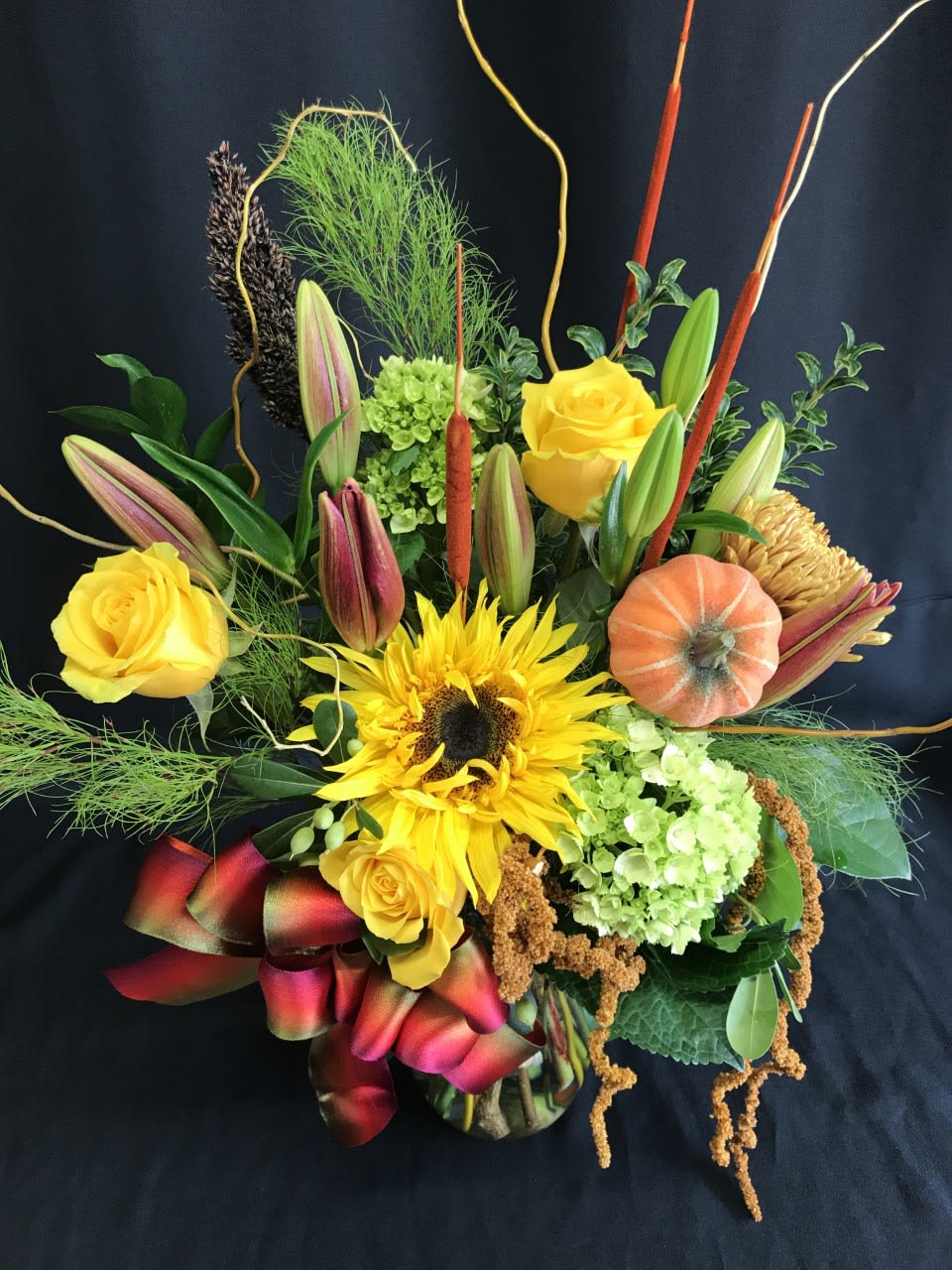Thanksgiving vase bouquet with lily buds 2 - Rich flower bouquet full of fall flowers. A sunflower and lily buds about to open that will last and last.You must order early for this type of assortment.  Long lasting and fun for fall.  Medium tall vased arrangement makes a lovely thank you gift or sentiment.  Assortment may vary.