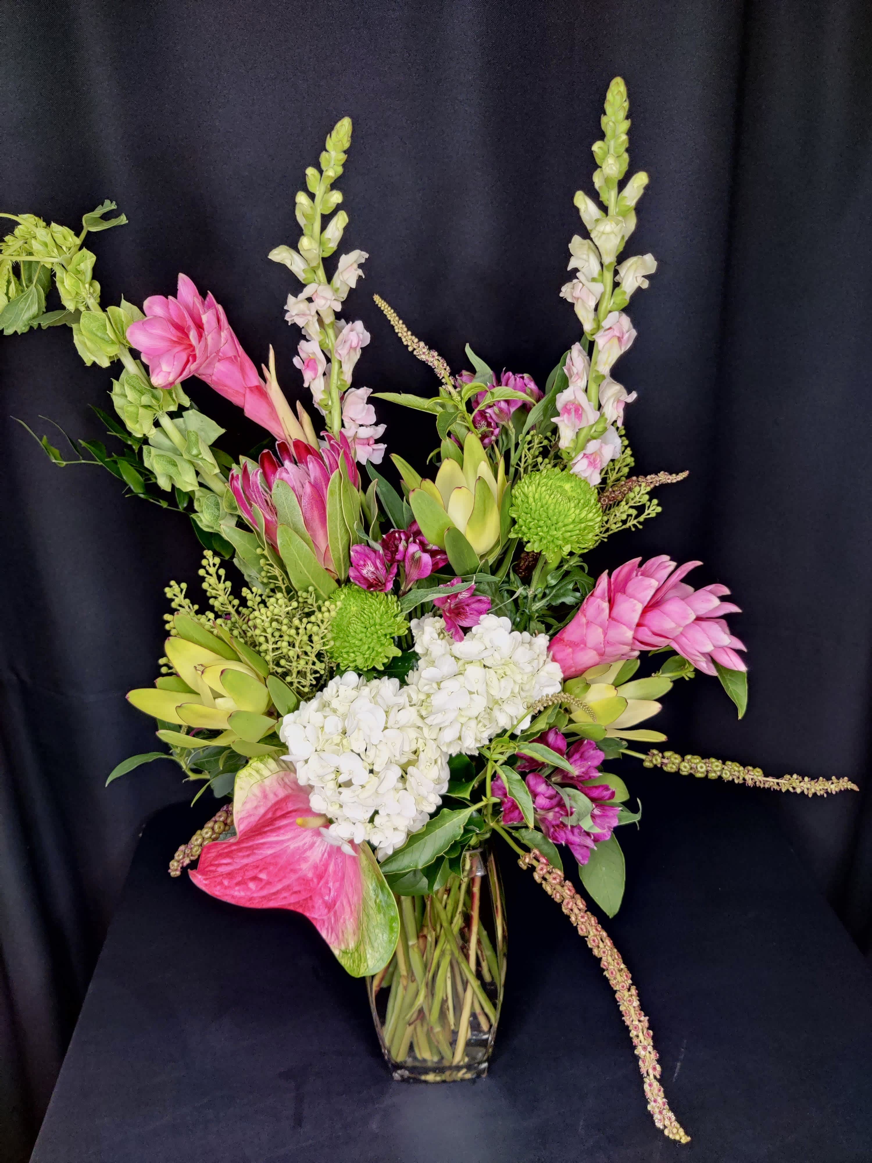 Ginger Protea Exotic mix in Vase Upgrade - High end design of exotic flowers. Assortment will vary. Shown here are King protea and giant anthurium with hydrangea and Bells of Ireland.    Tall and stylish bouquet for an anniversary or valentine's day.