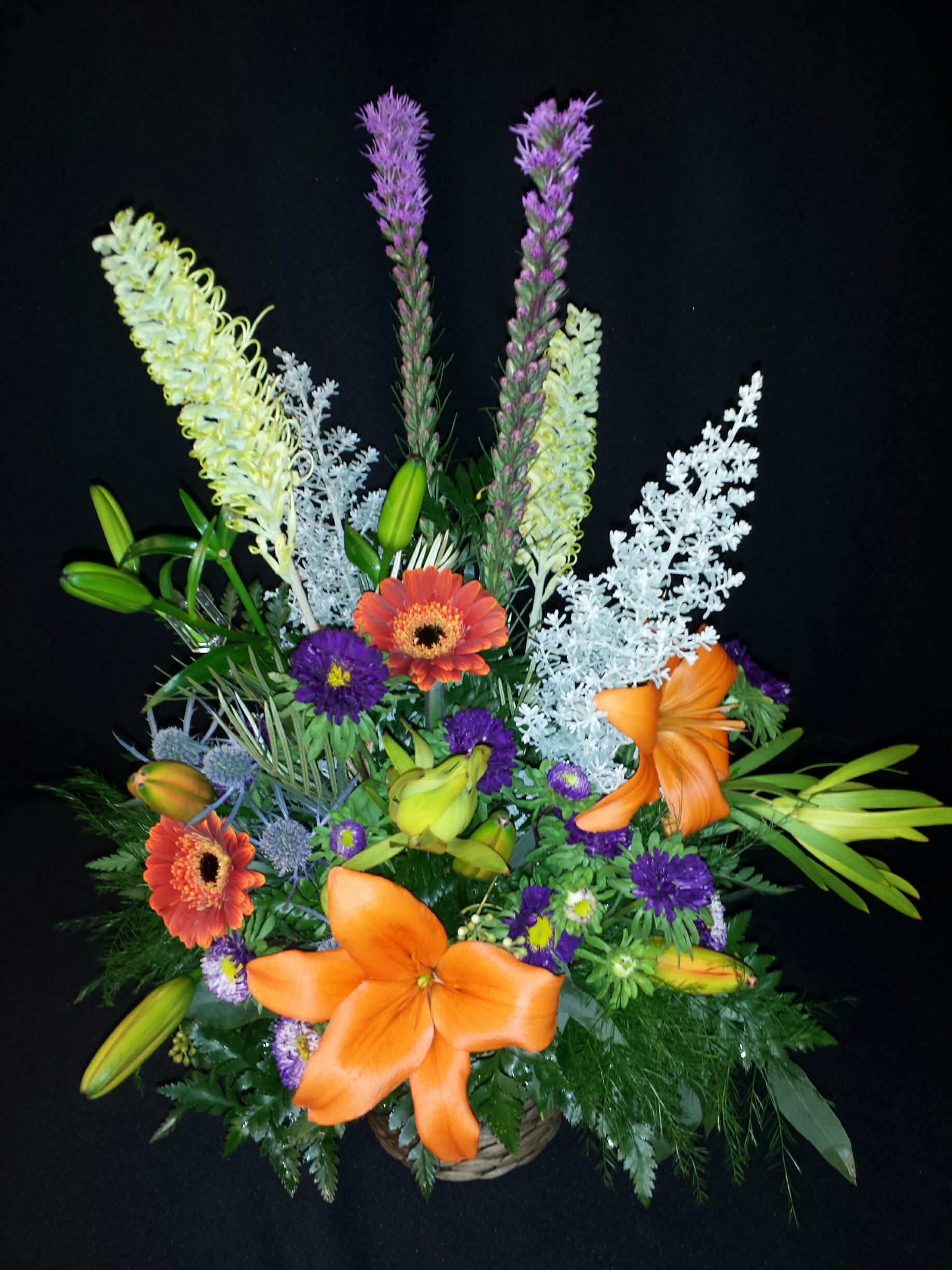 Small Basket Spray for the Service - Sweet seasonal flowers in floral foam can be easily transported home by the family since there will not be water splashing in a vase.  These sit well on any surface, lawn, carpet, tabletops.  Container, color and flower assortment will vary. If you'd like to request colors or flowers, be sure you have ordered a full week ahead.