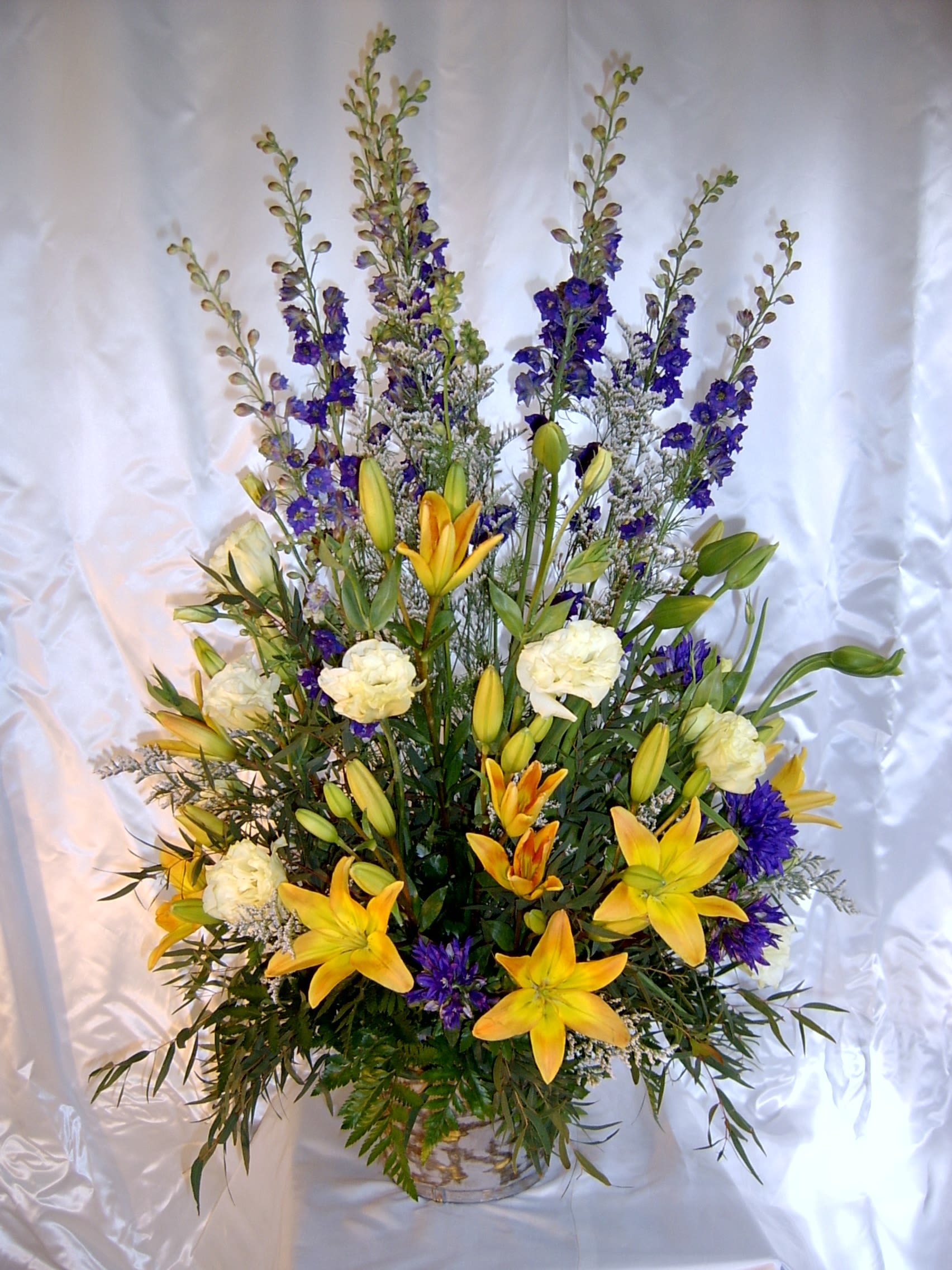 Memorial Spring Mixed Basket - Tall and lovely assortment of all premium flowers.  Assortment and colors will vary. This is well contained in a basket with floral foam so that no water will splash around if transported after the service. Very impressive size and quality of flowers. *Be sure to order a full week ahead if you'd like to specify Colors or Flowers.