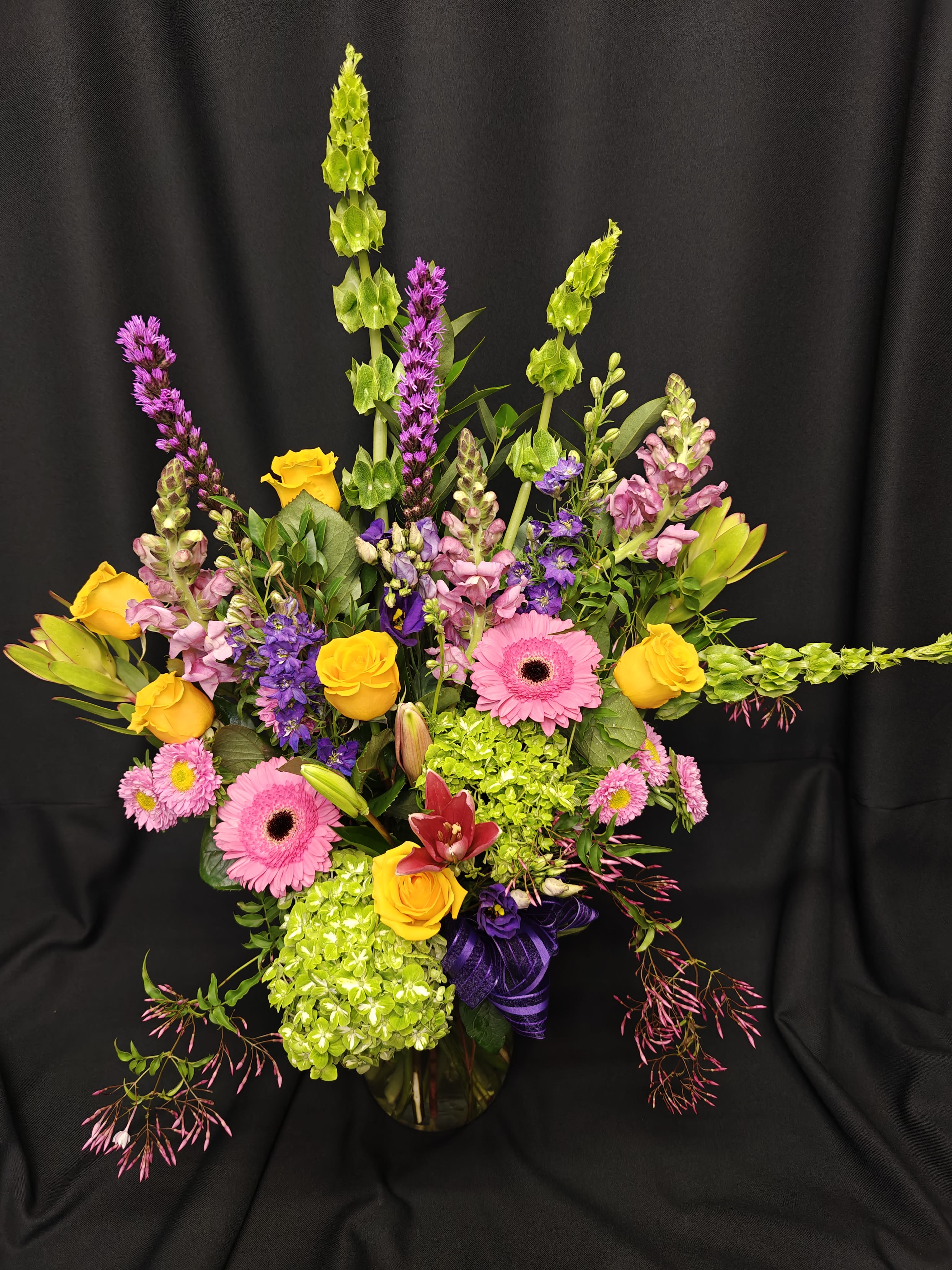 Colorful mixed flower arrangement with pink gerberas and yellow roses in a vase