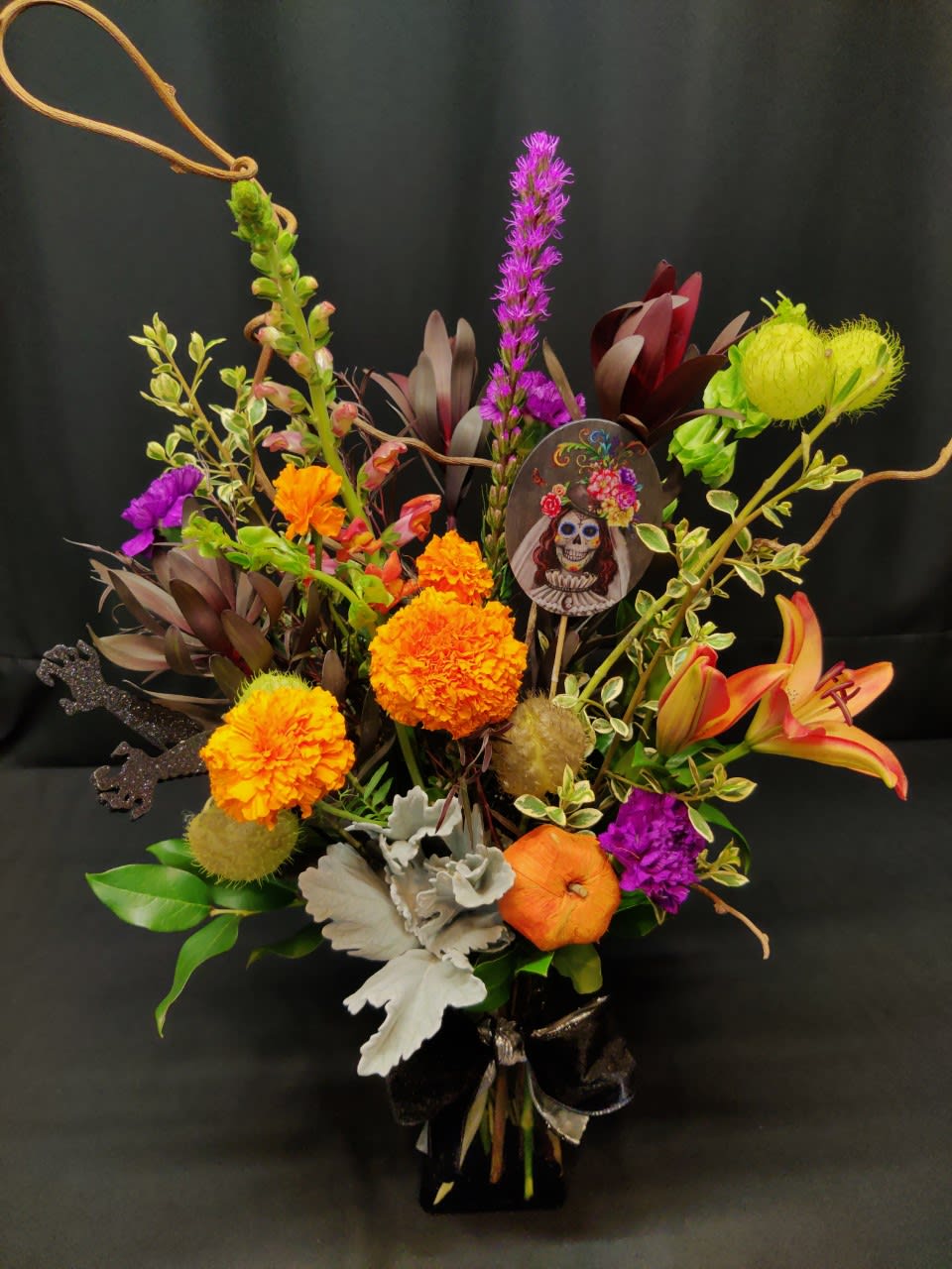 Dia de los Muertos Bouquet - Honor your loved ones who have passed on with a colorful dia de los muertos bouquet. Gone but never forgotten. Festive for Halloween too. Bright flowers and accents will vary. 