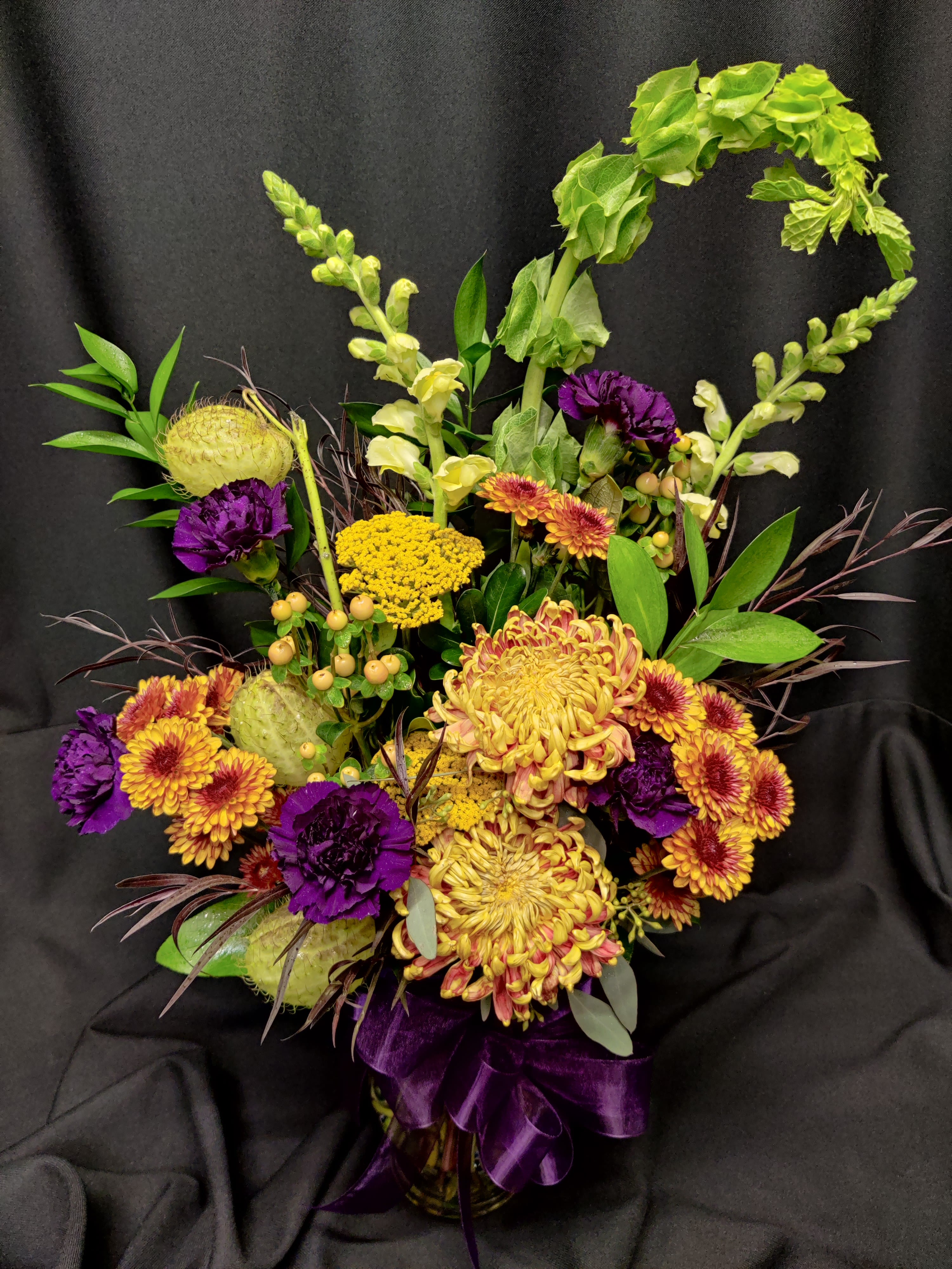 Fall or Halloween Vibe - Purples, greens and fall colors combine for a moody festive flavor. Exact flowers will vary. 