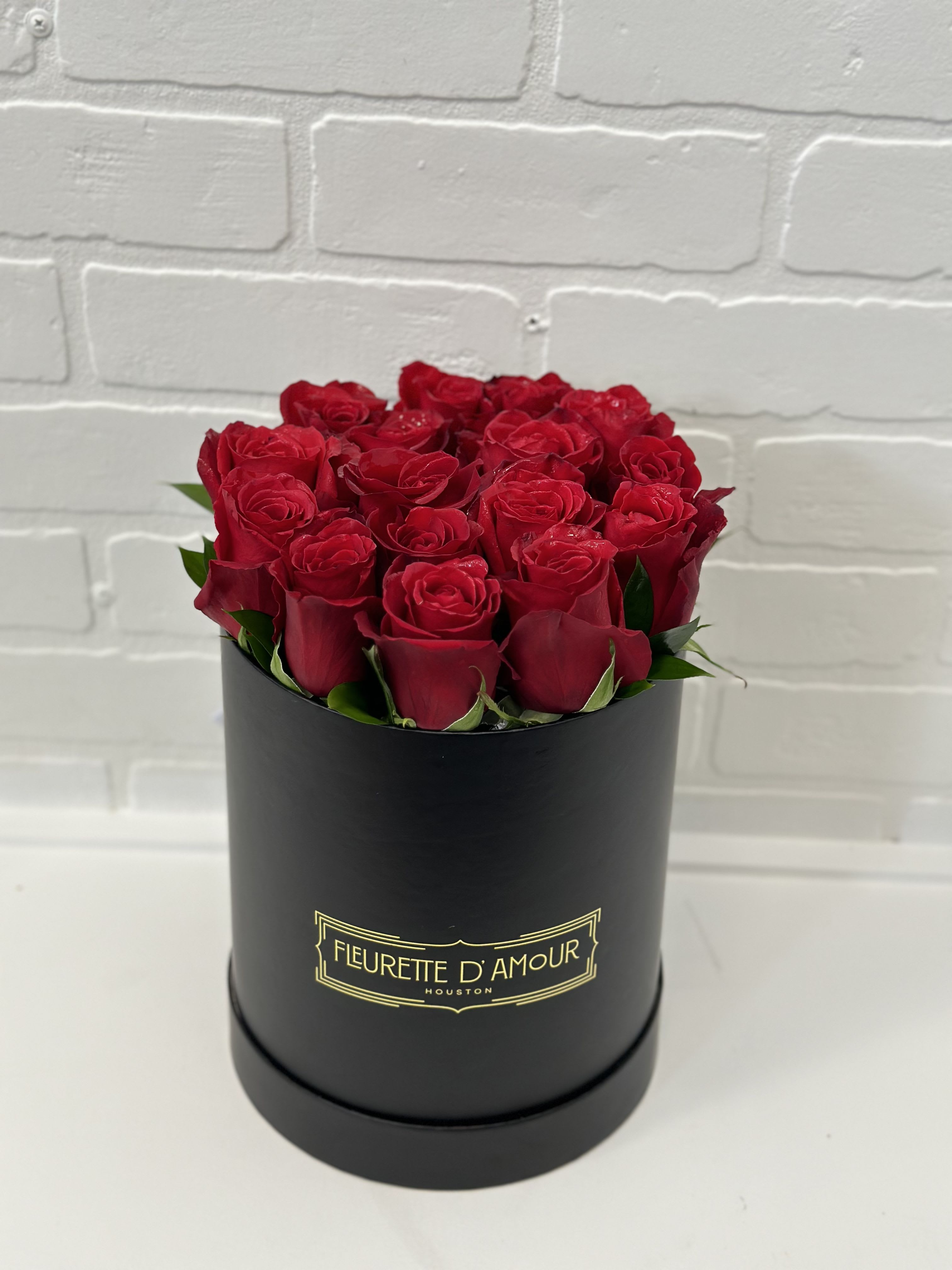 Red roses arranged in a black round box