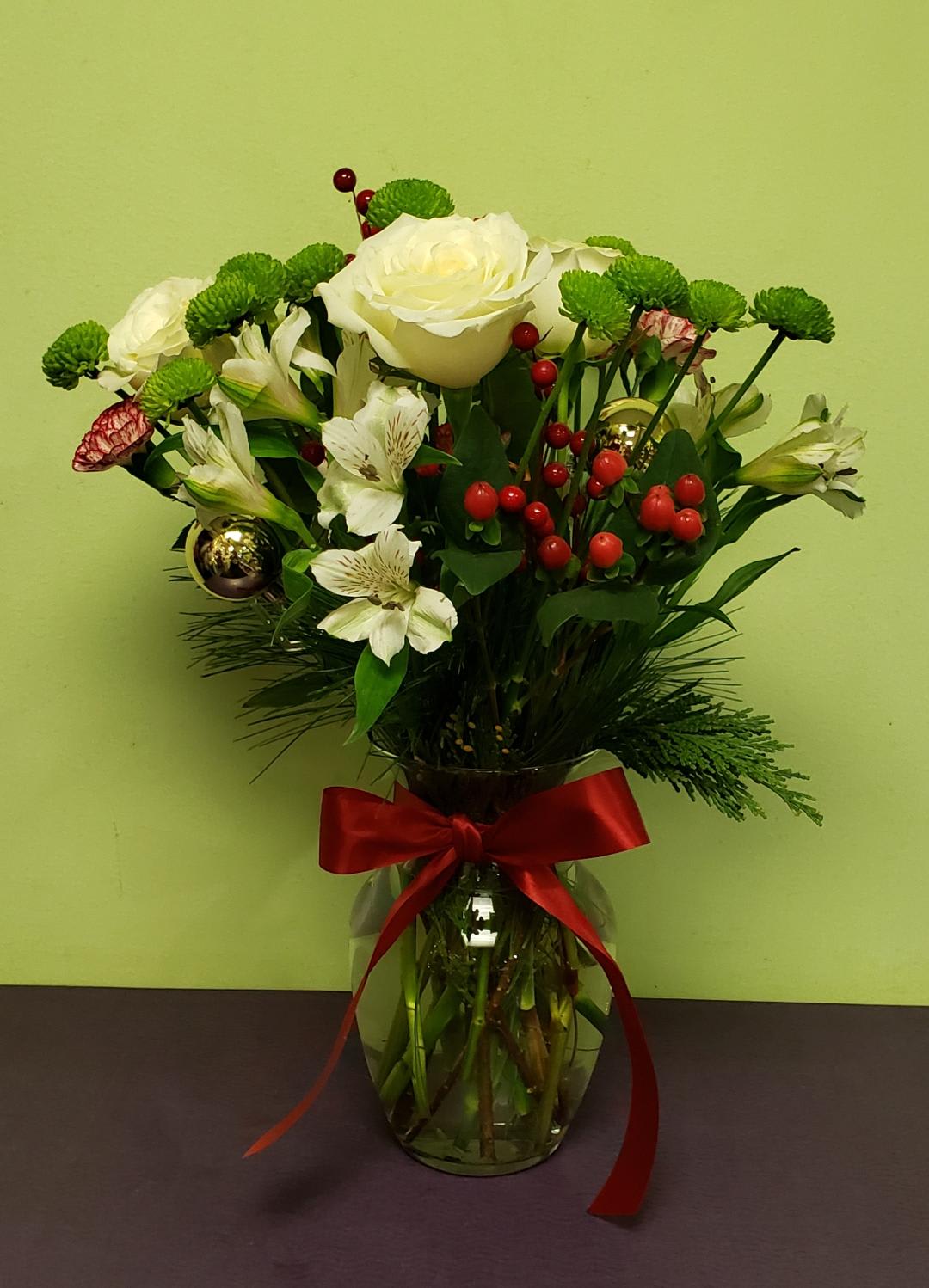 Bouquet of white roses and alstroemeria in a glass vase with a red ribbon