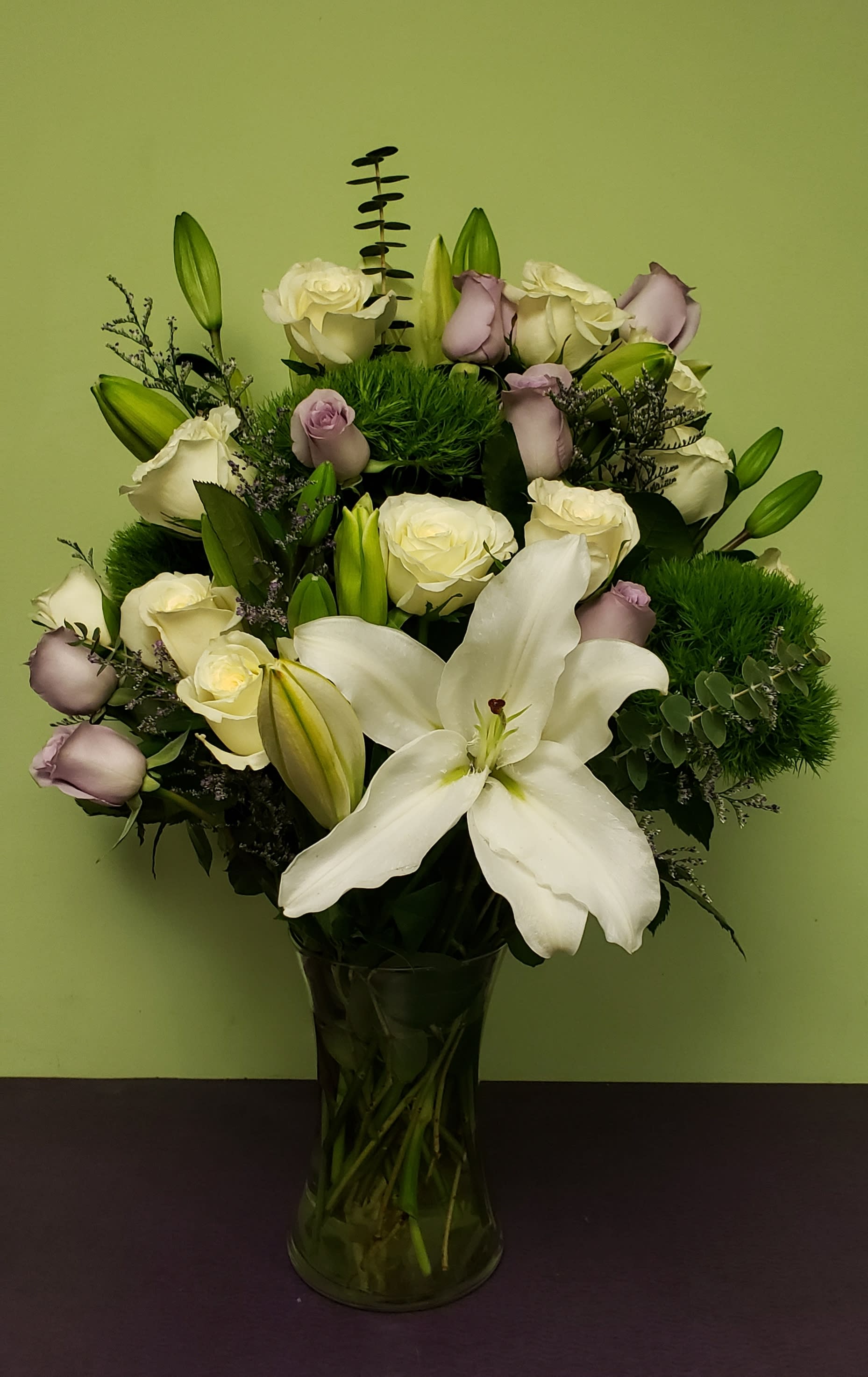 White lilies and pale roses in a glass vase