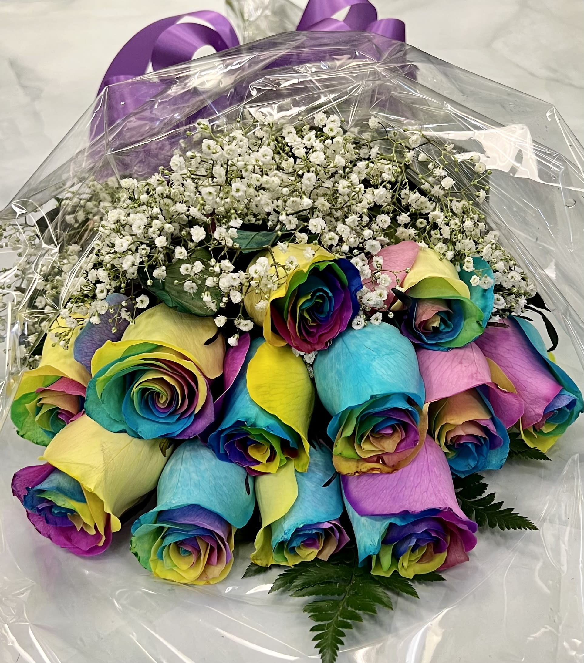 Bouquet of rainbow-colored roses with white baby's breath