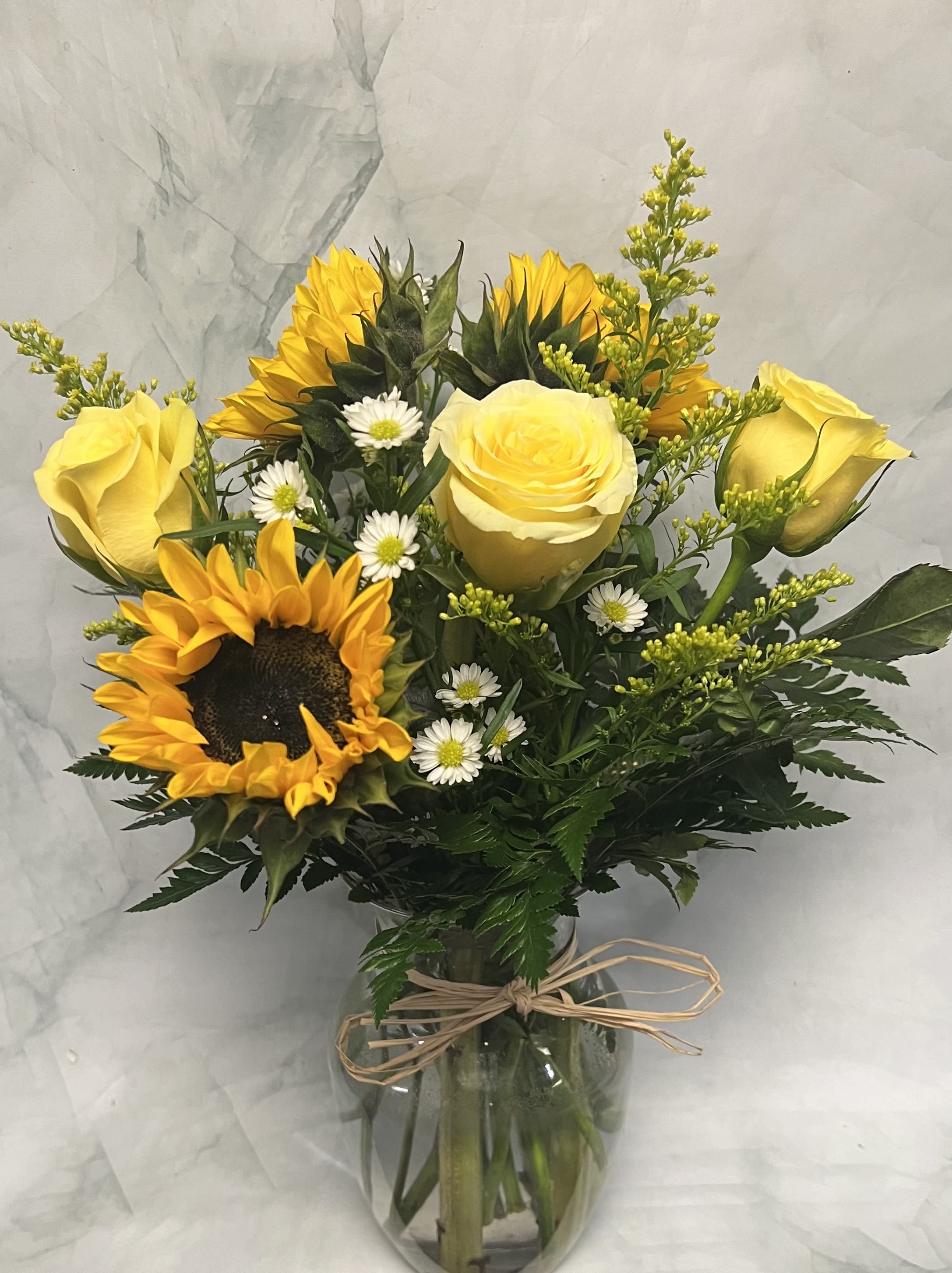 Bouquet of yellow roses and sunflowers in a glass vase