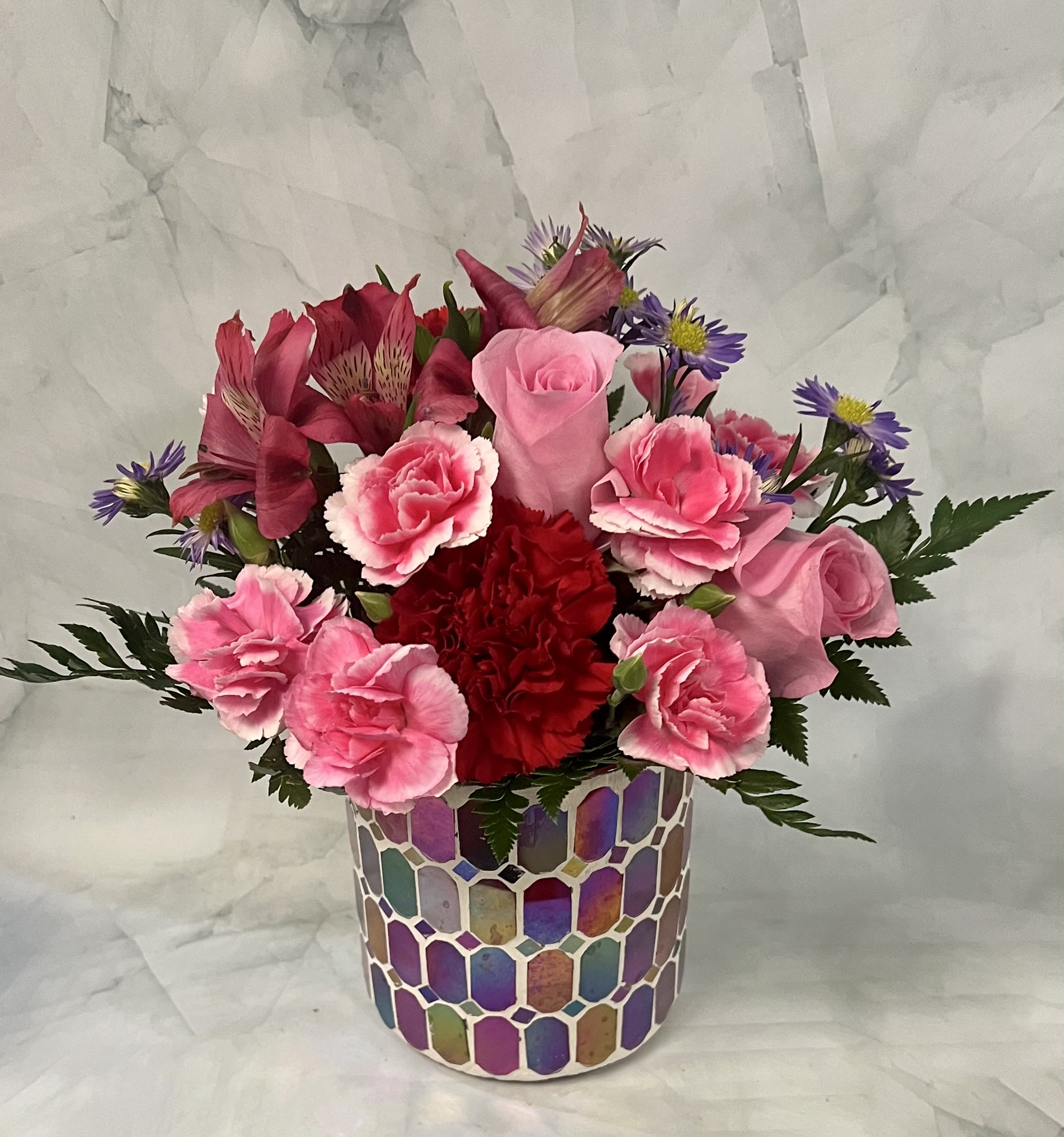 Pink and red mixed bouquet in a colorful mosaic vase