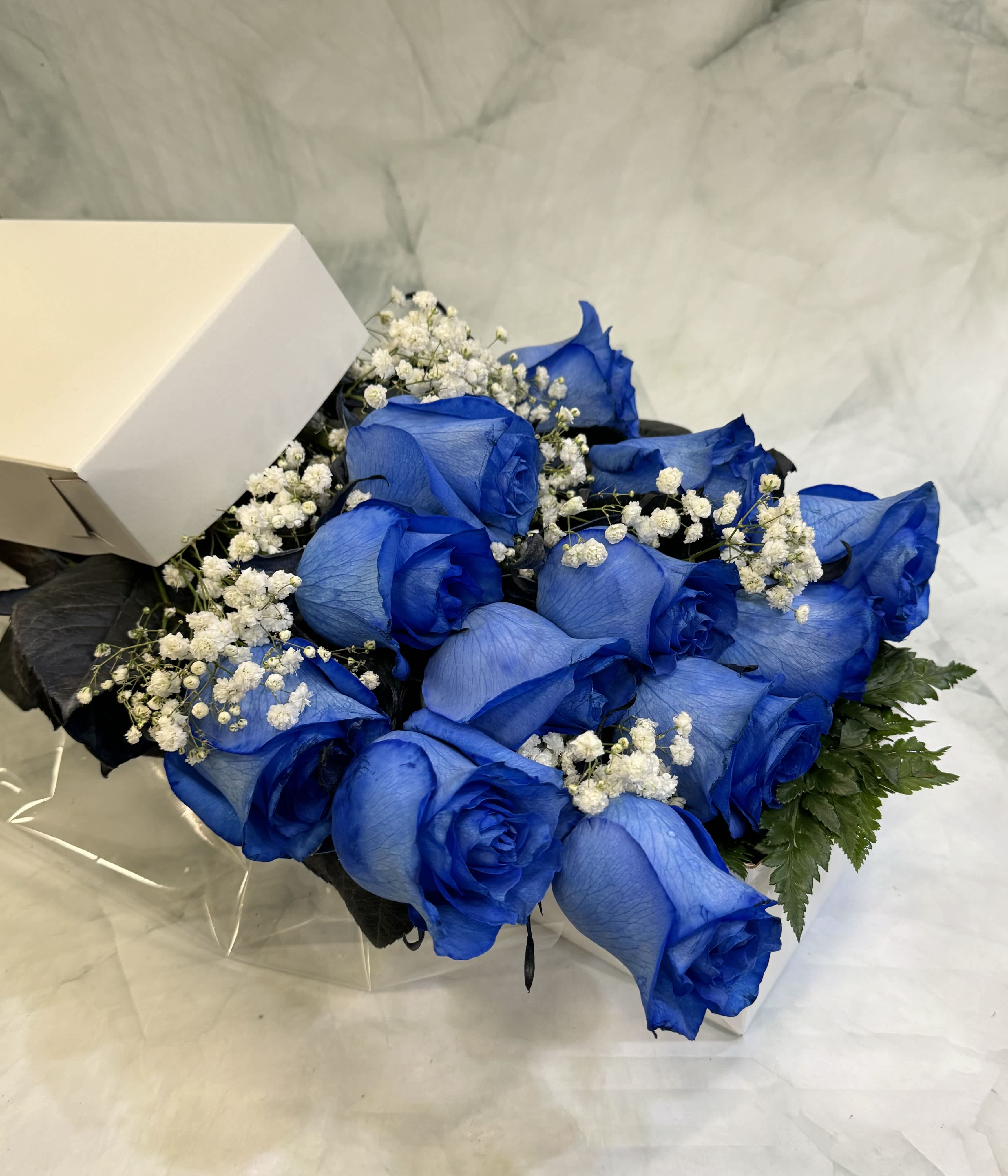Bouquet of blue roses with white baby's breath in a box