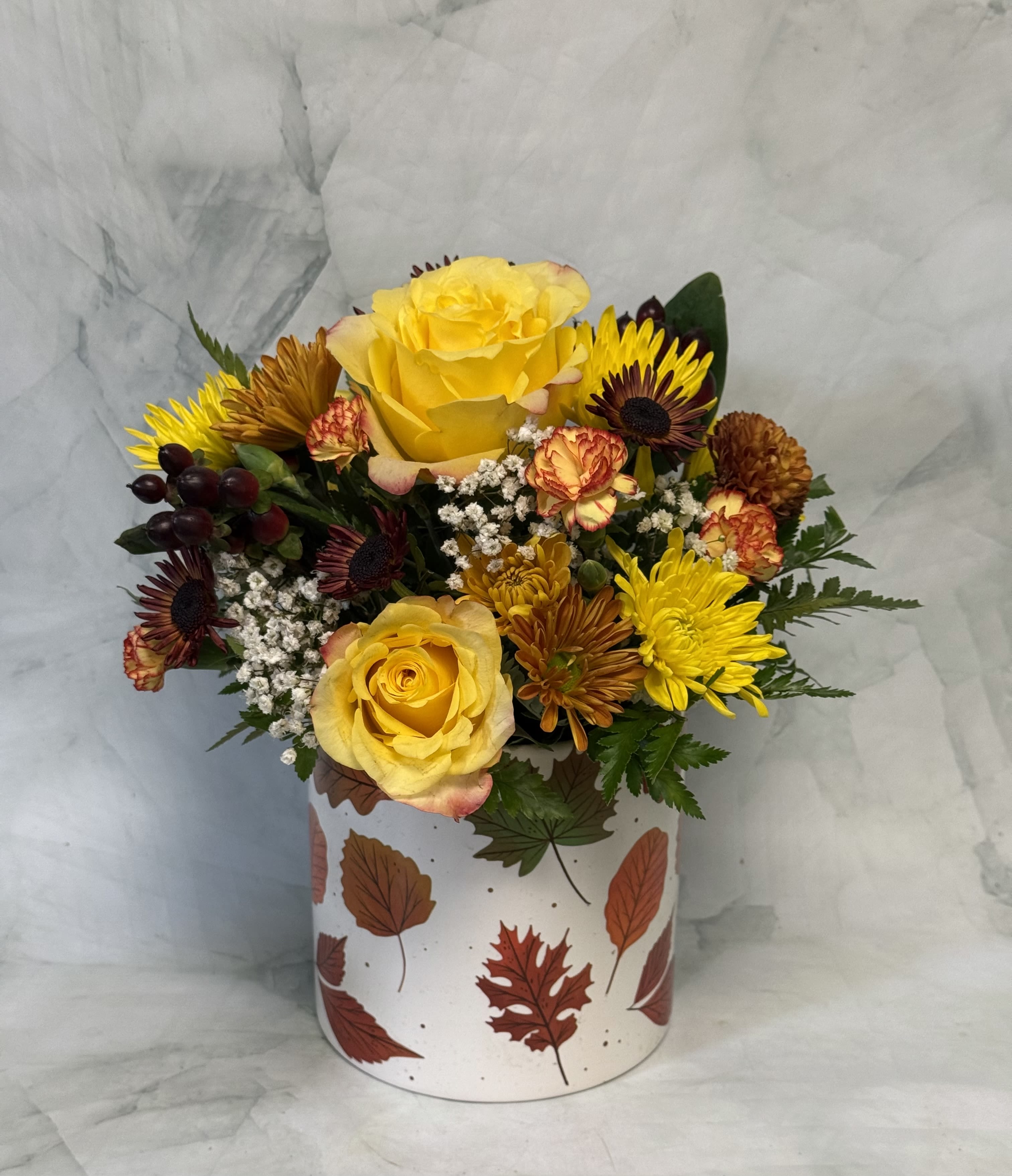 Yellow roses and mixed chrysanthemums in a leaf-patterned box