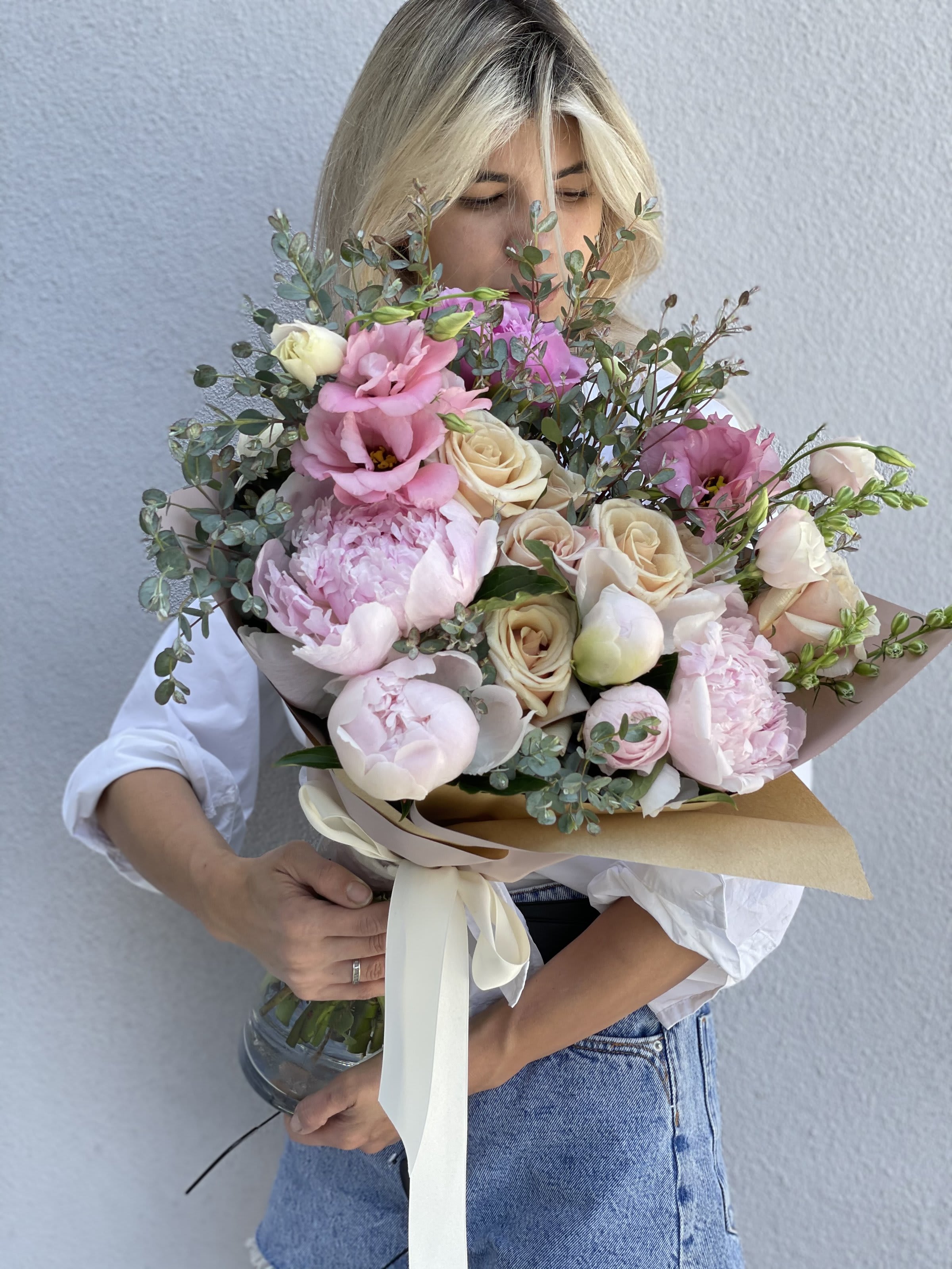 Large bouquet of pink and cream flowers wrapped in paper