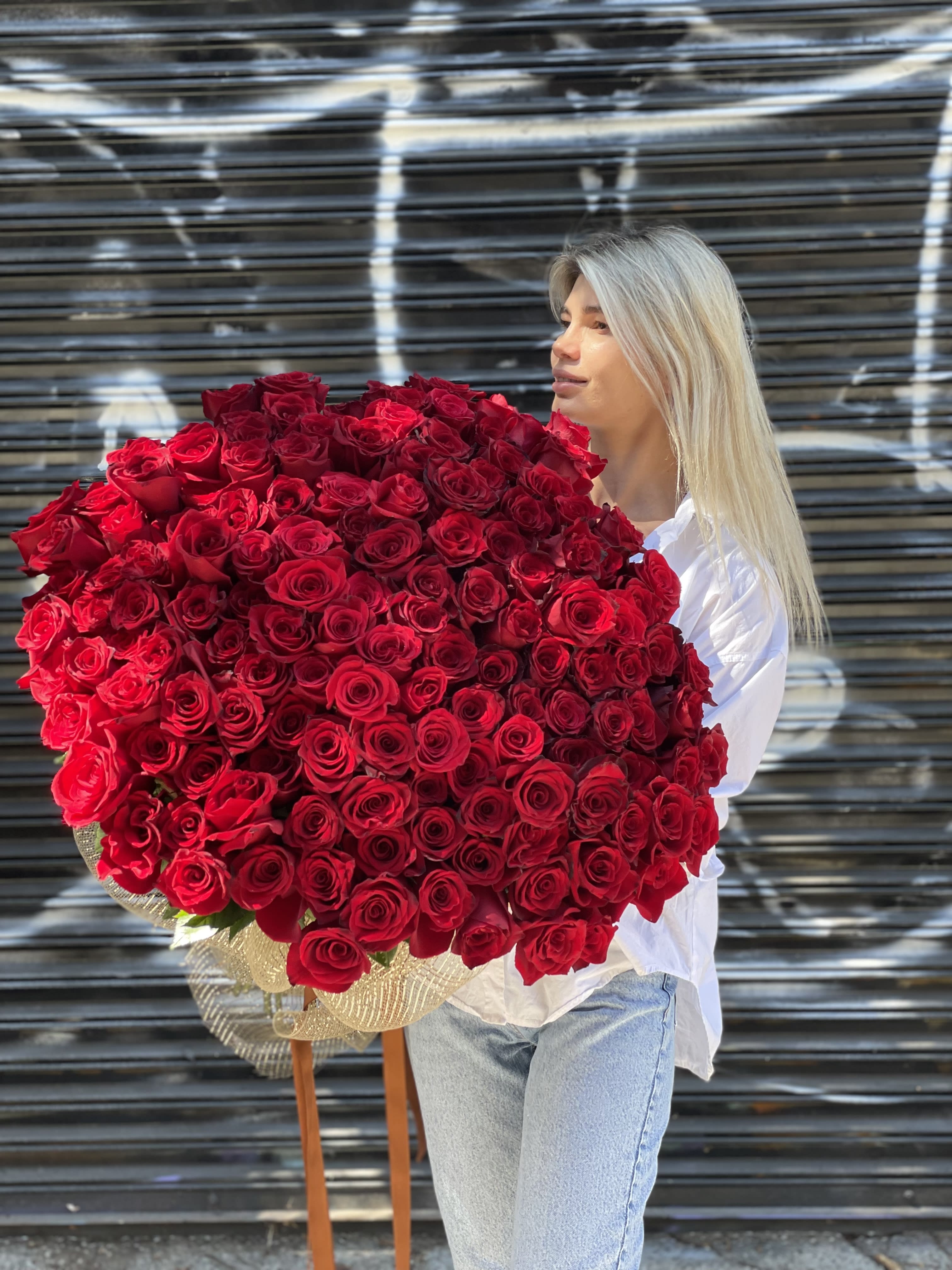 Woman holding a large bouquet of red roses