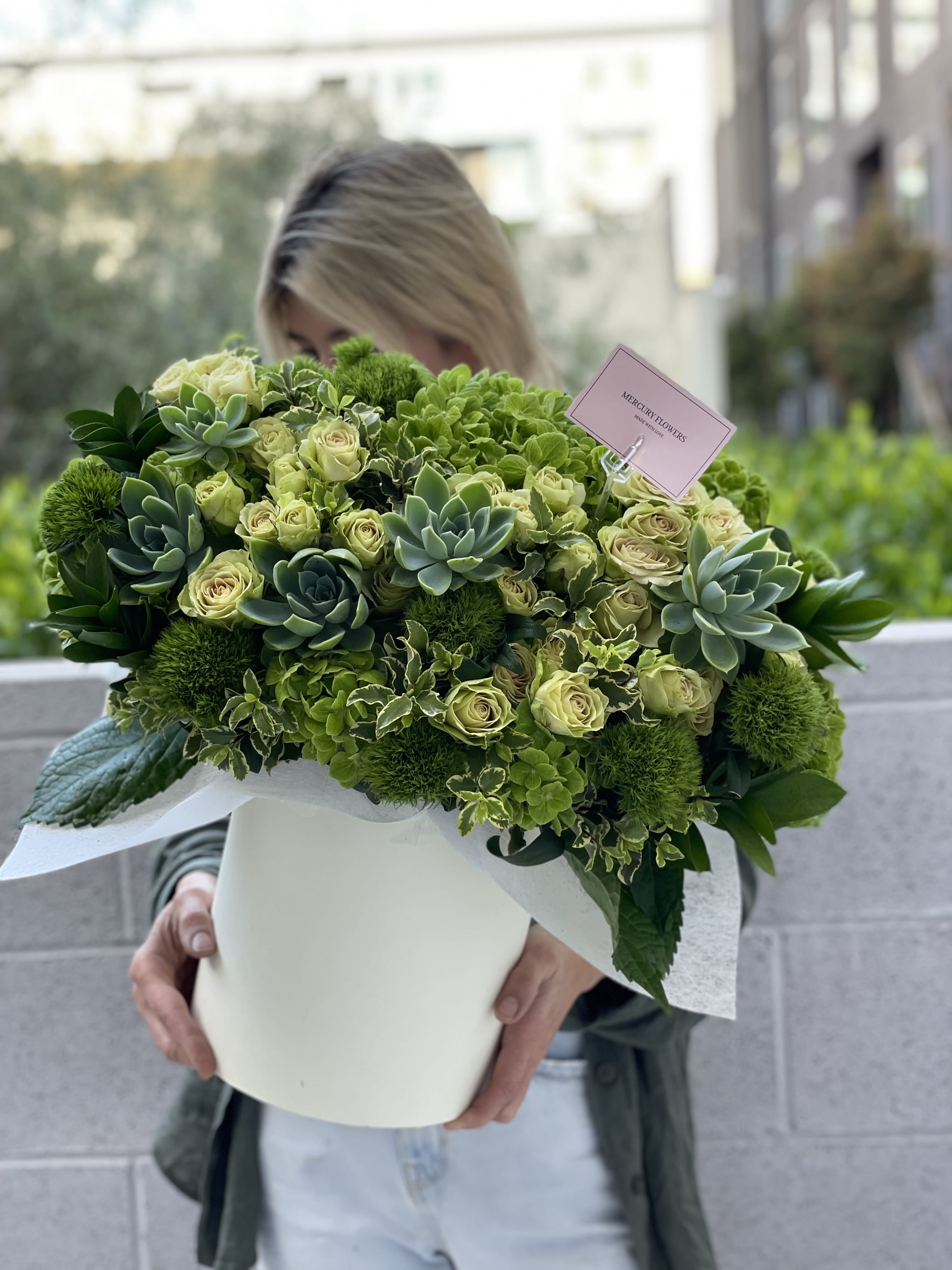 Large green bouquet with roses and succulents in a white box