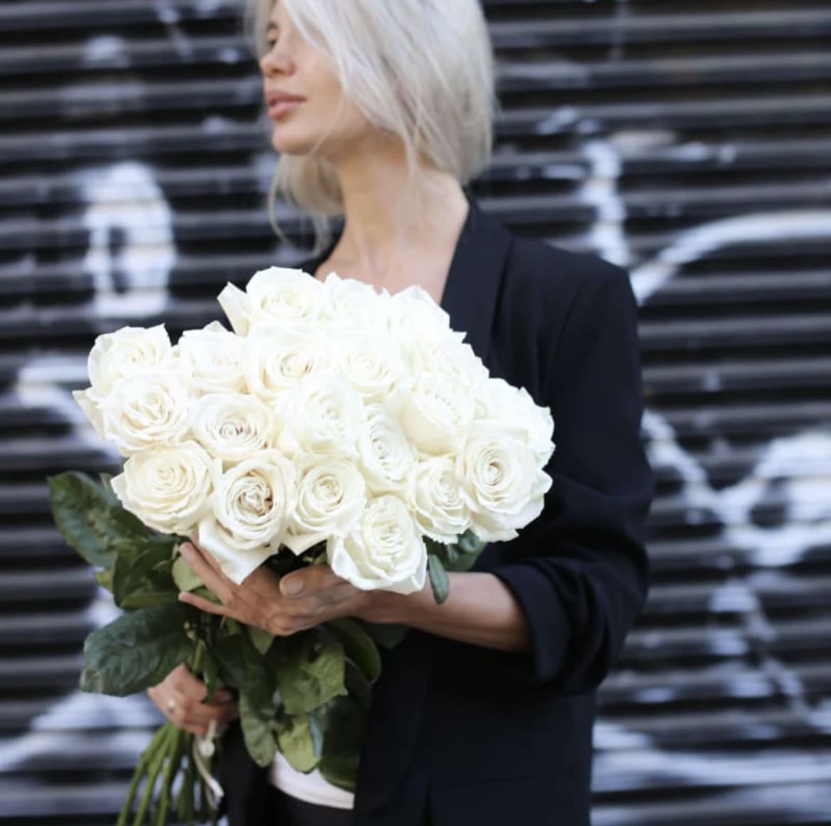 Woman holding a large bouquet of white roses