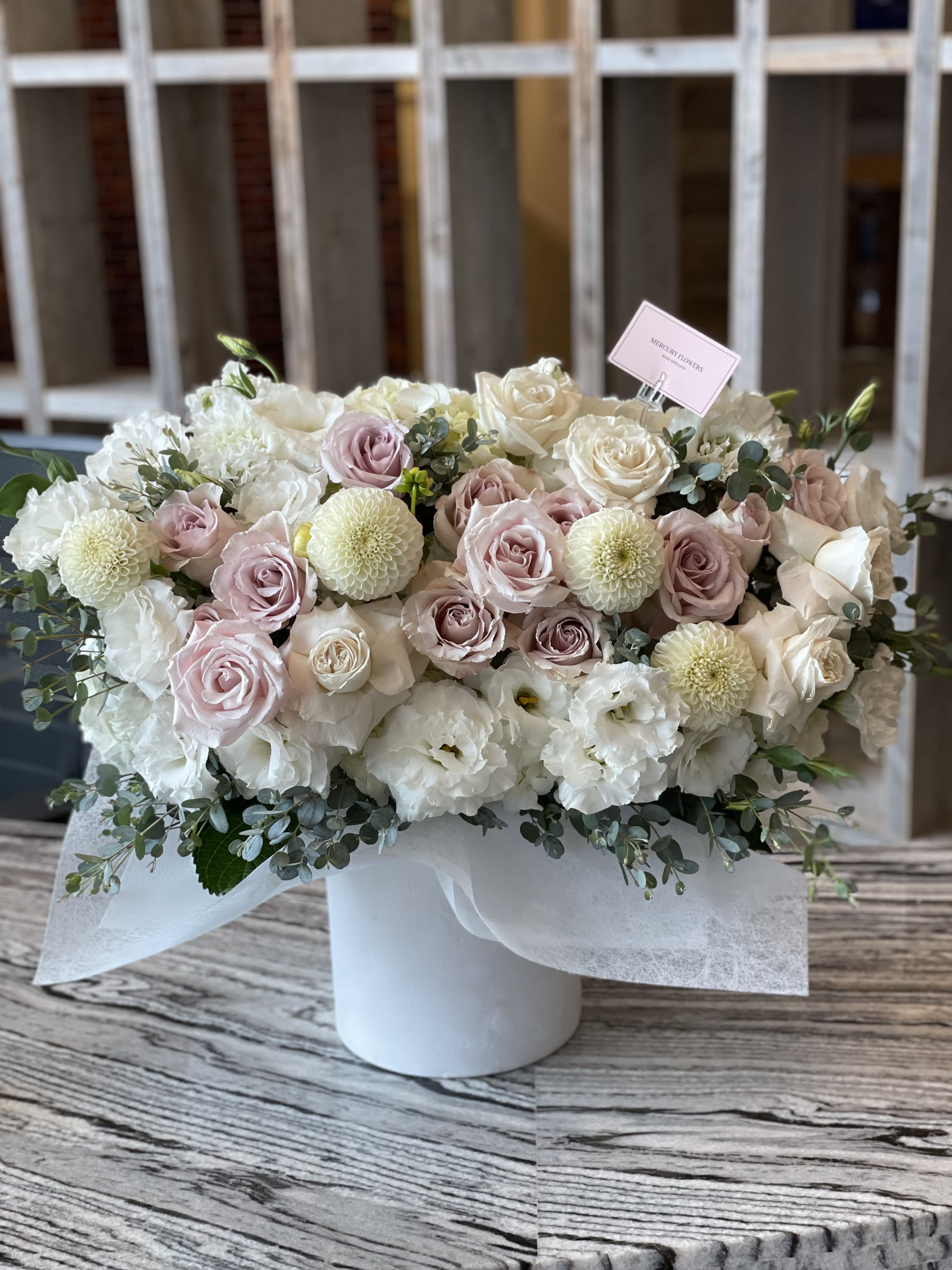 Pastel rose and white flower arrangement in a white box