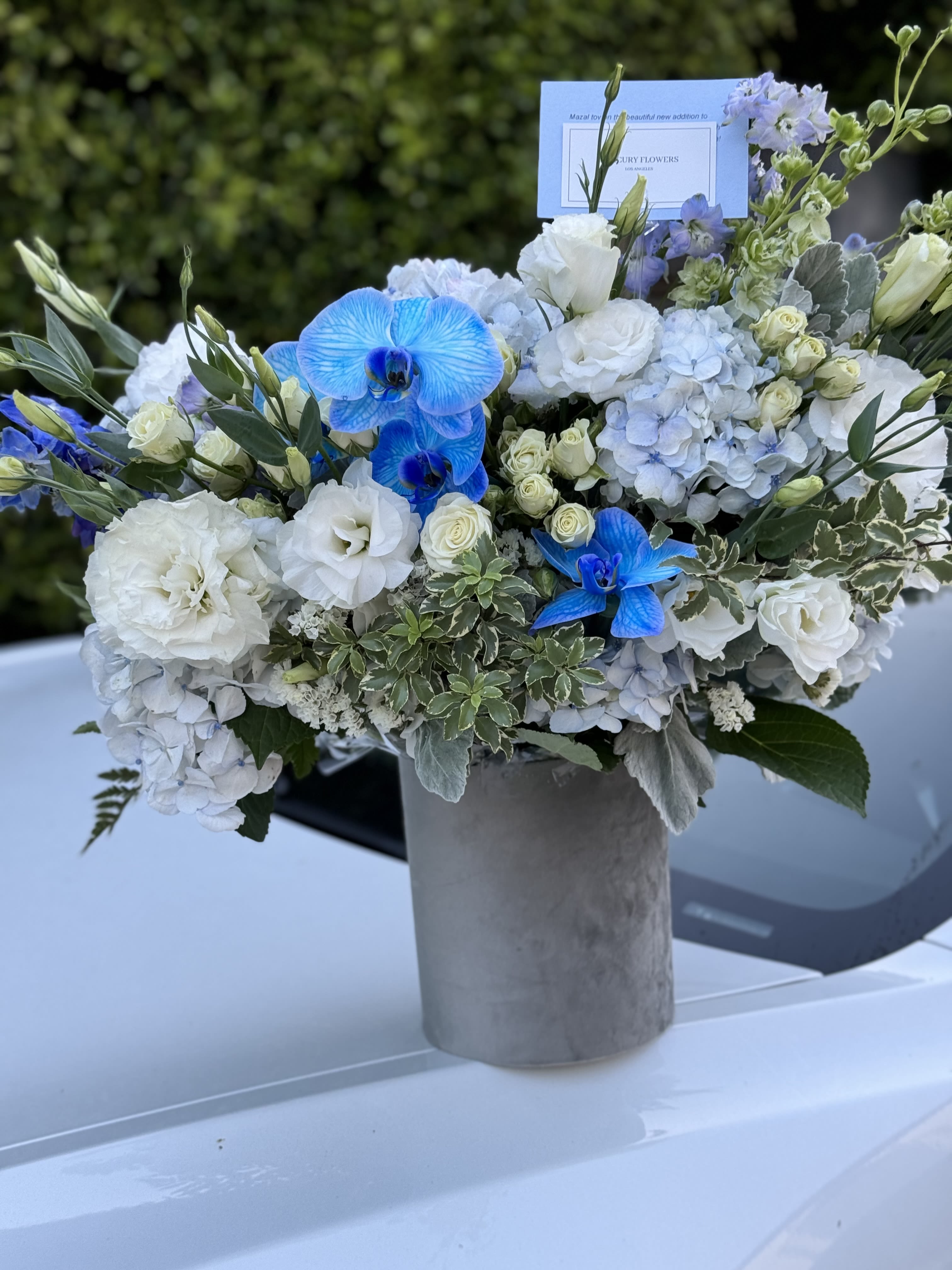 Blue and white floral arrangement in a gray vase