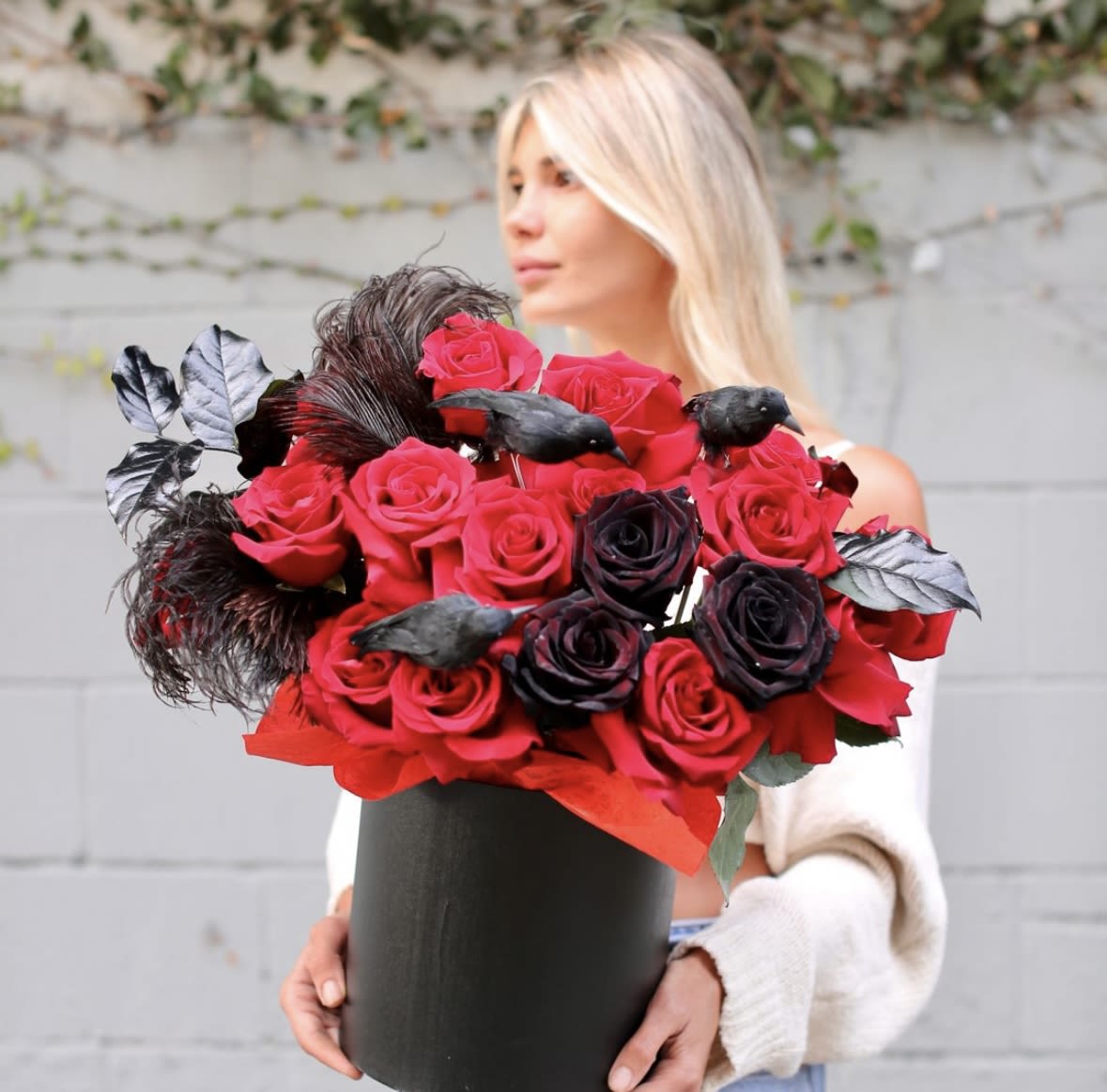 Woman holding a black box of red and black roses