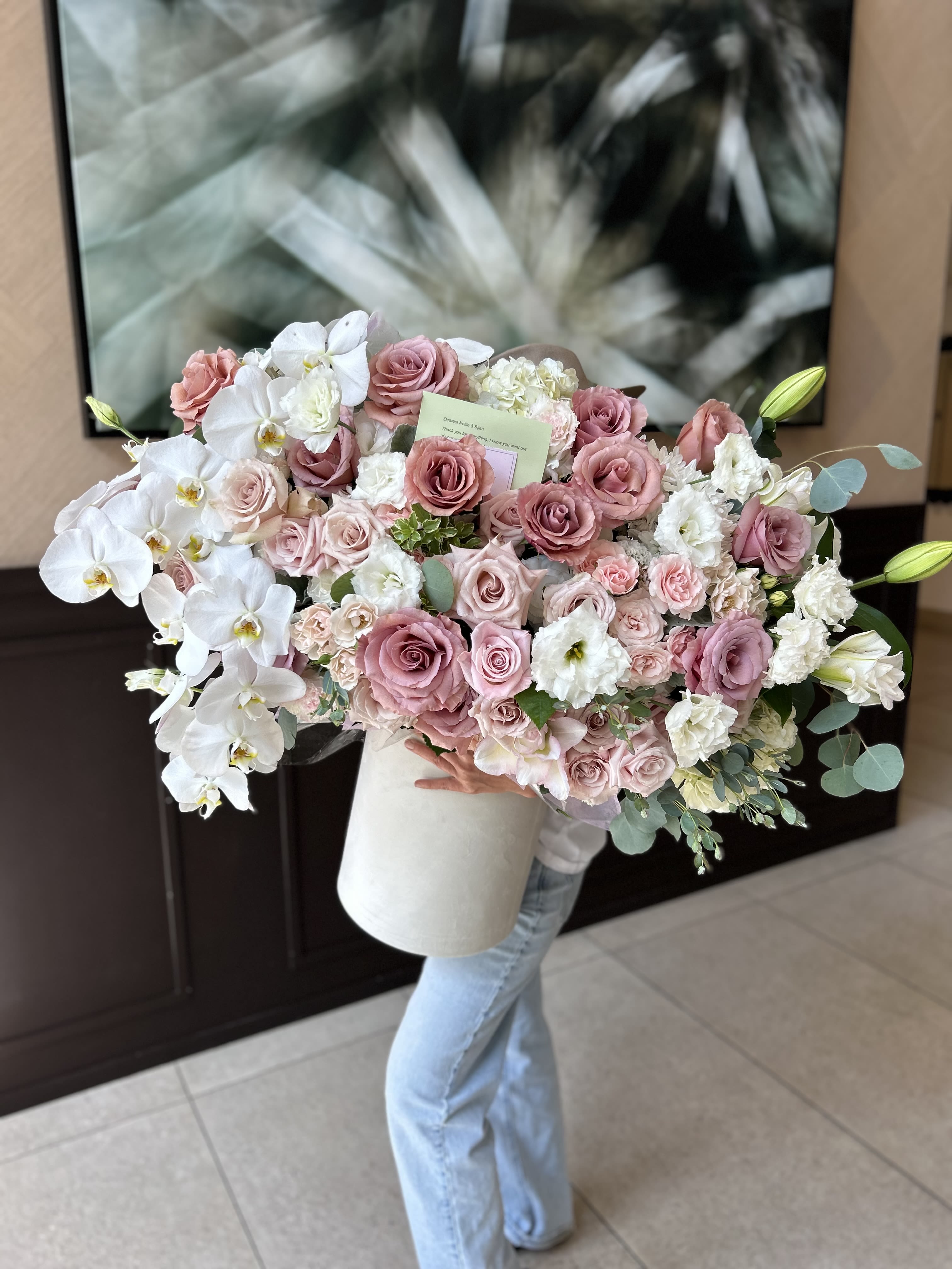 Large bouquet of pink roses and white orchids in a white box