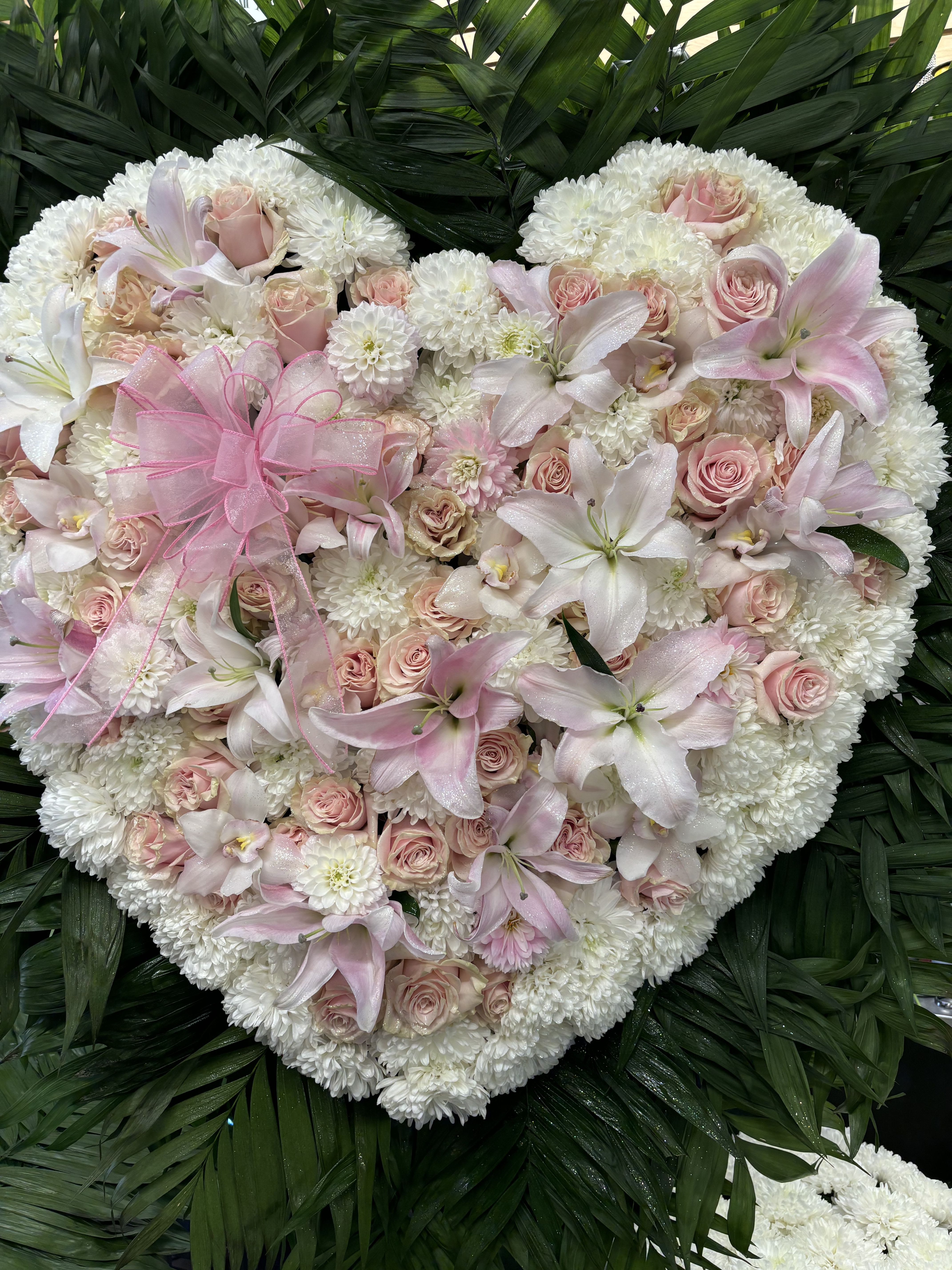 Heart-shaped floral arrangement with pink roses and white lilies