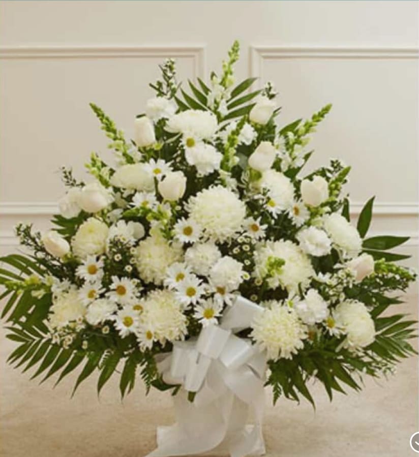 White floral standing spray with daisies, carnations, and roses