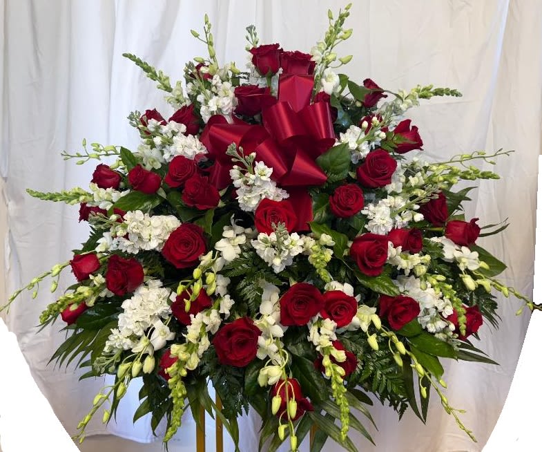 Large red rose and white flower arrangement with a red bow