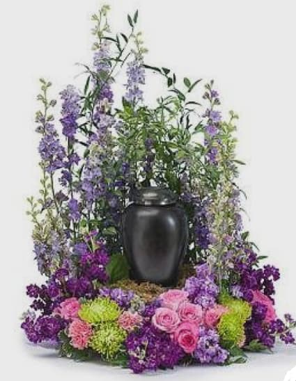 Purple and pink floral arrangement in a black urn vase